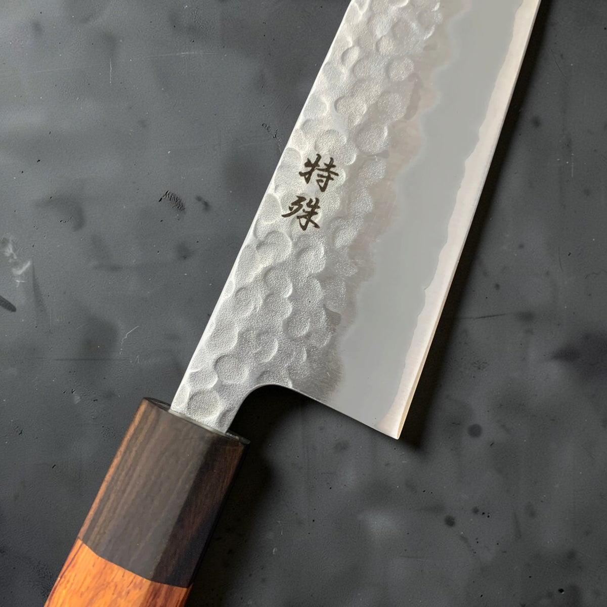 Close-up of Tokushu kanji, hammered tsuchime finish, blade heel and ebony ferrule