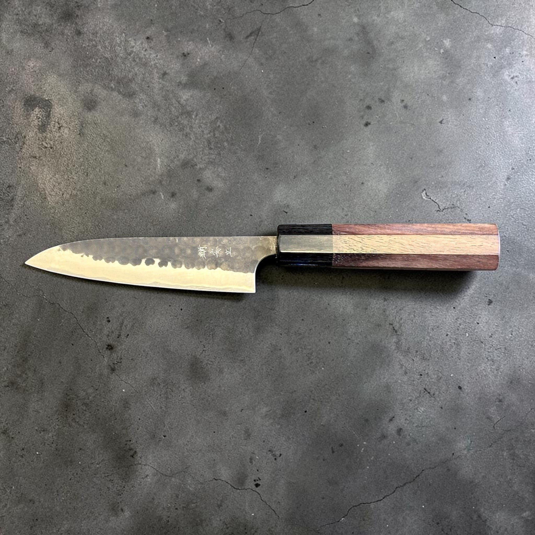 Anryu Aogami Super Kuro Tsuchime Petty 120 mm with rosewood octagon handle, reverse full profile highlighting the kanji engraving and dark hammered blade finish.