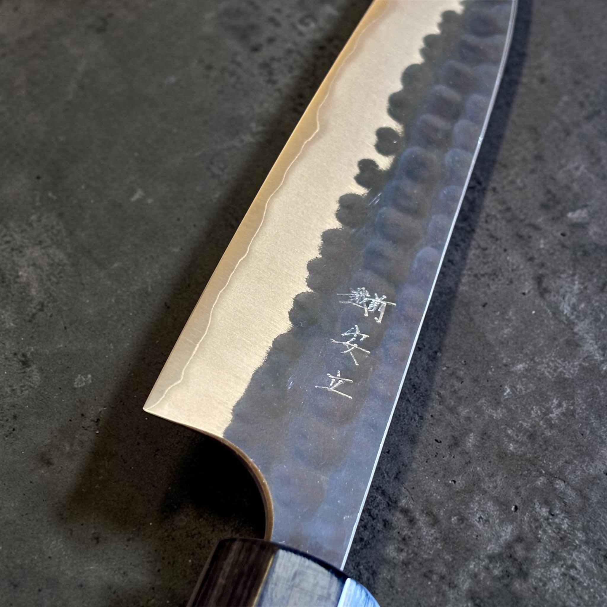 Anryu Aogami Super Kuro Tsuchime Petty 150 mm, close-up of the blade face with engraved kanji, hamon-like transition line, and dark hammered finish.