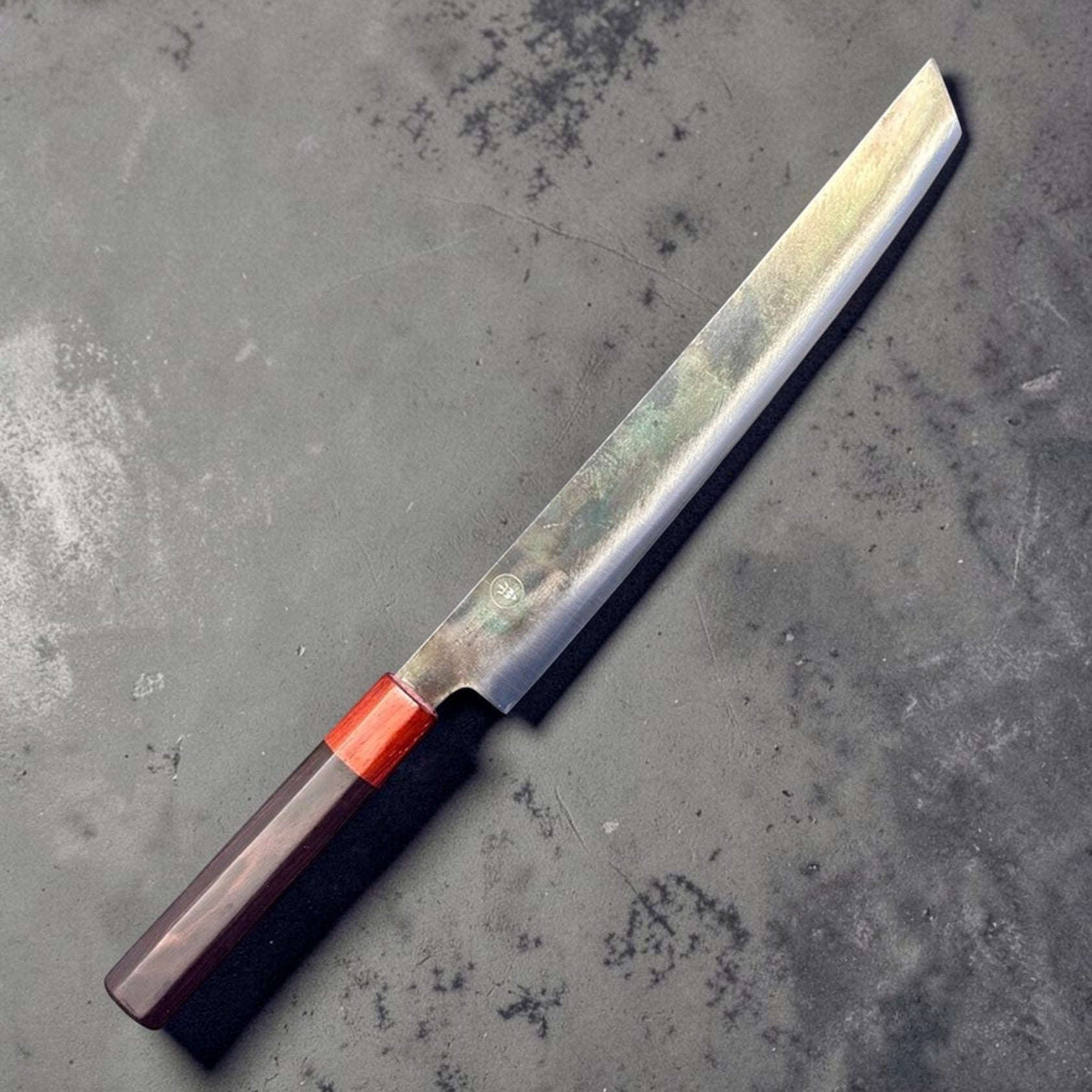 Dao Vua V3 52100 carbon steel 270 mm sakimaru sujihiki slicer, angled right-side product view showing maker's mark and polished blade finish.