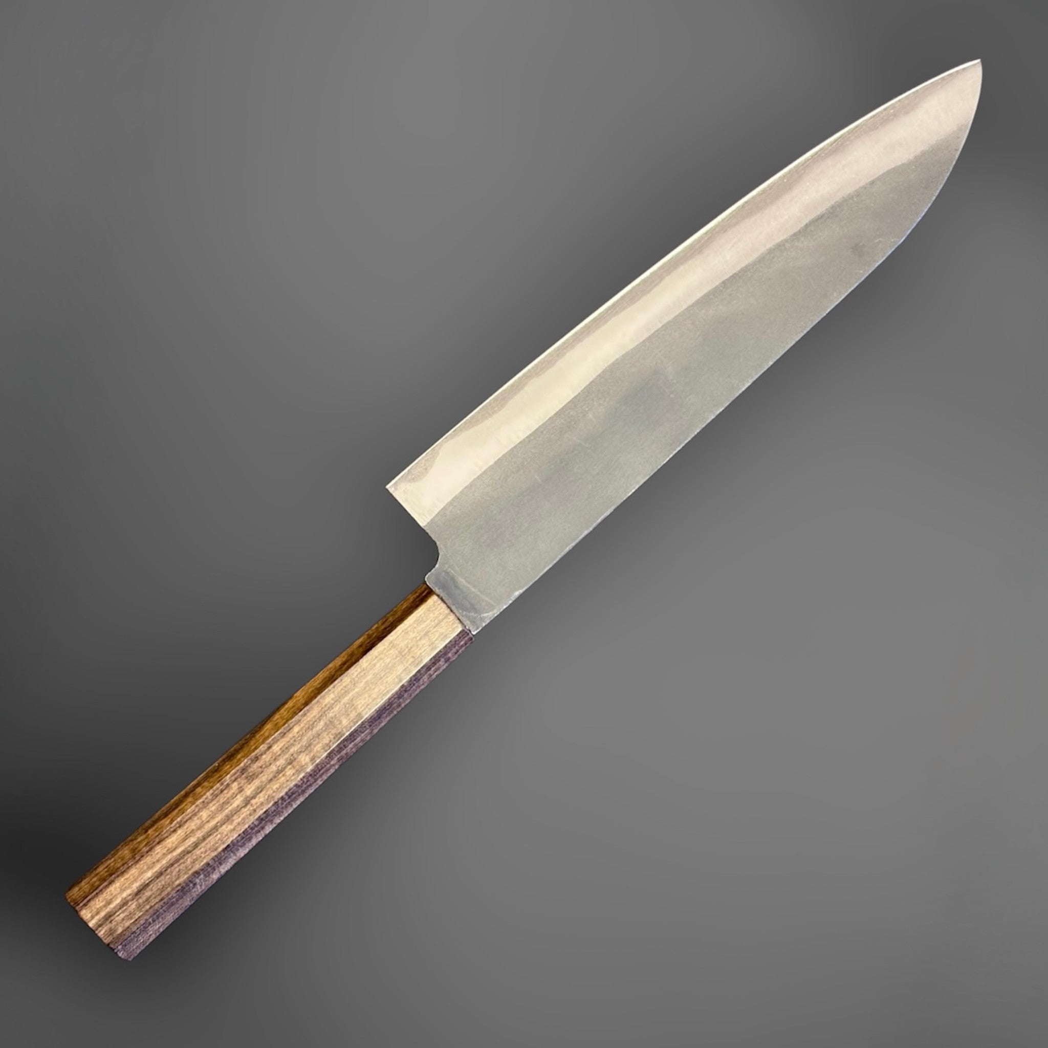 Hatsukokoro Blue #2 Kurouchi Gyuto 220 mm with mono ebony handle, angled view highlighting the kurouchi finish and edge line.