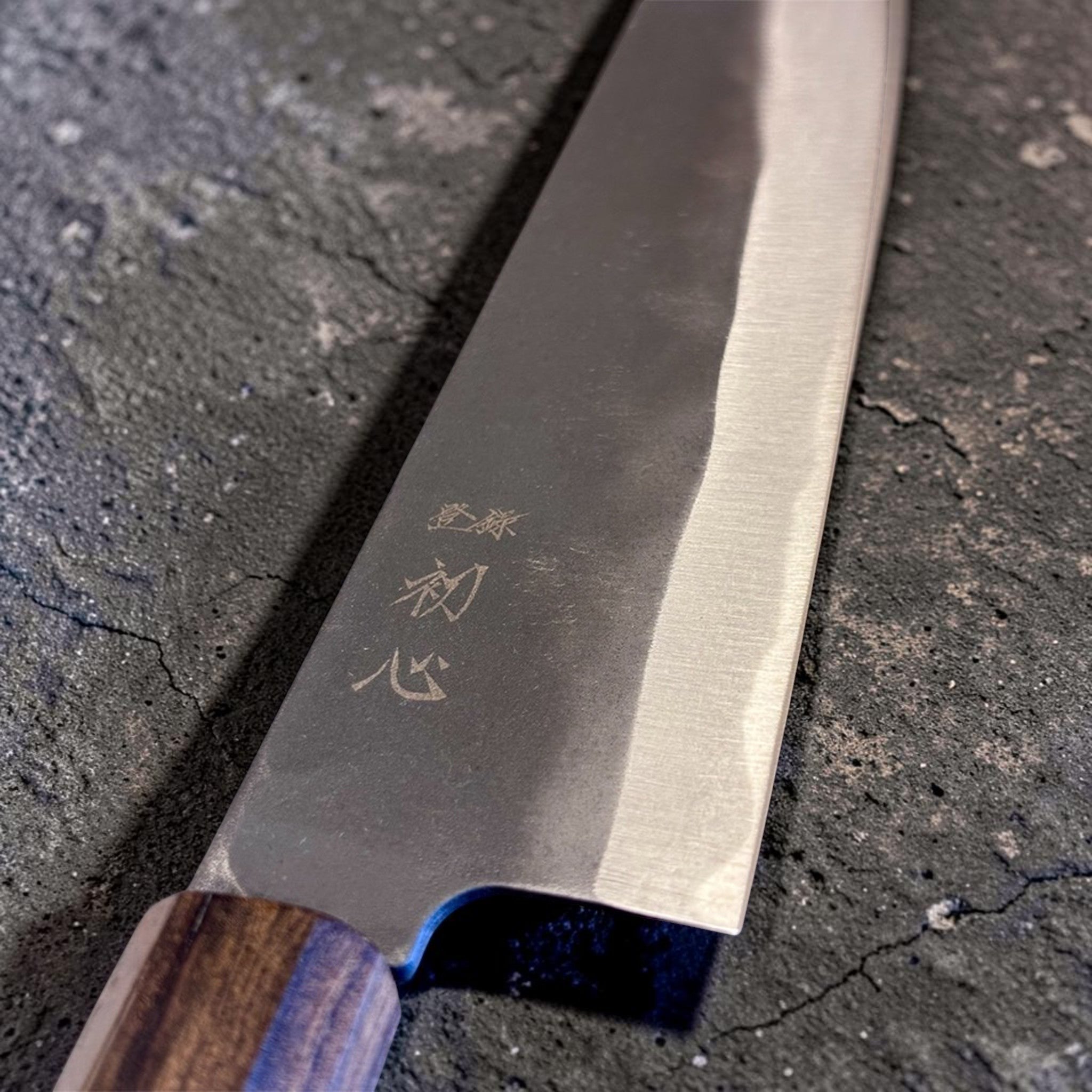 Hatsukokoro Blue #2 Kurouchi Gyuto 220 mm, close-up of the heel area with engraved kanji and kurouchi finish.