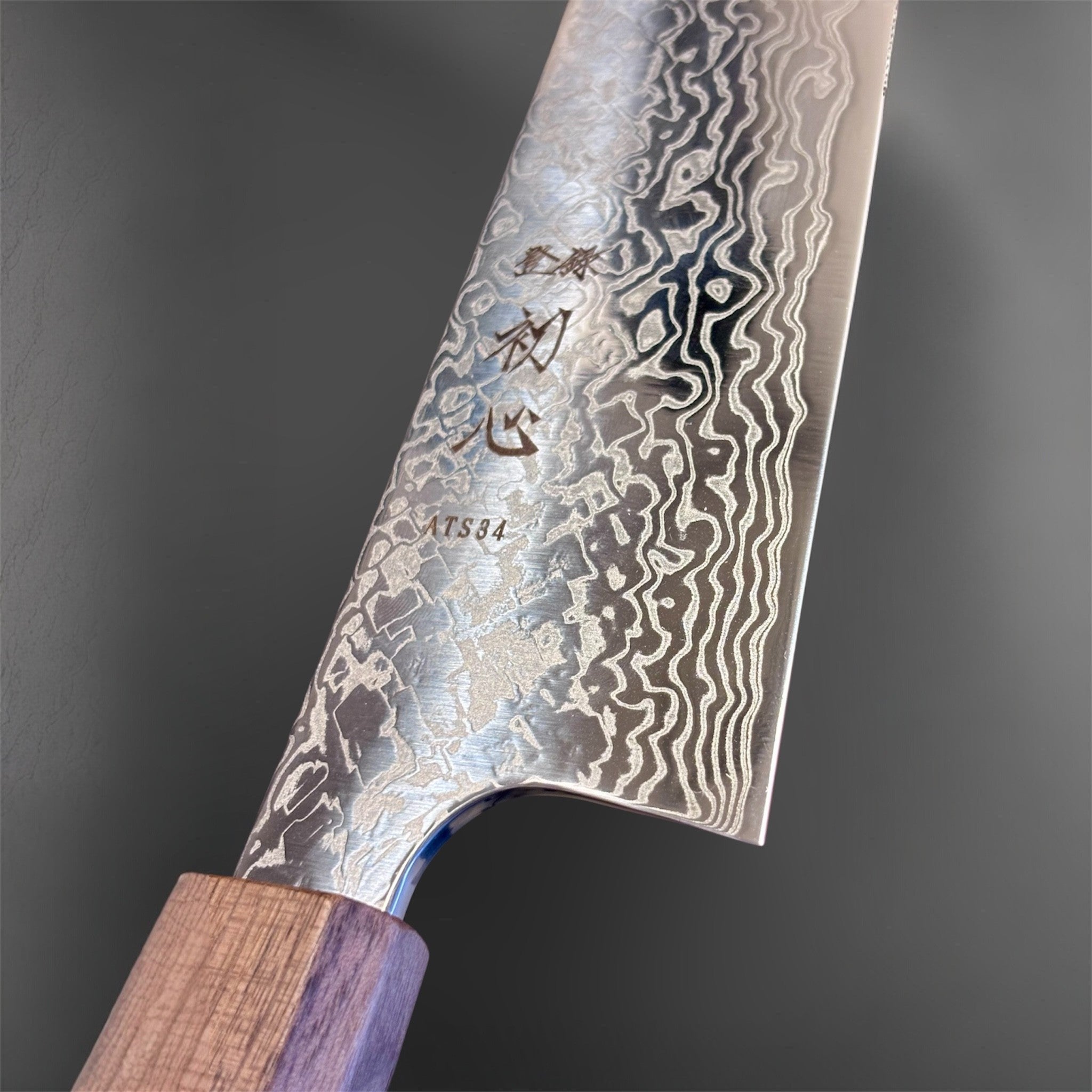 Hatsukokoro Ginga ATS-34 Nickel Damascus Gyuto 210 mm with Sanjo walnut handle and maple stripe, close-up of the blade heel, engraving, and Damascus detail.