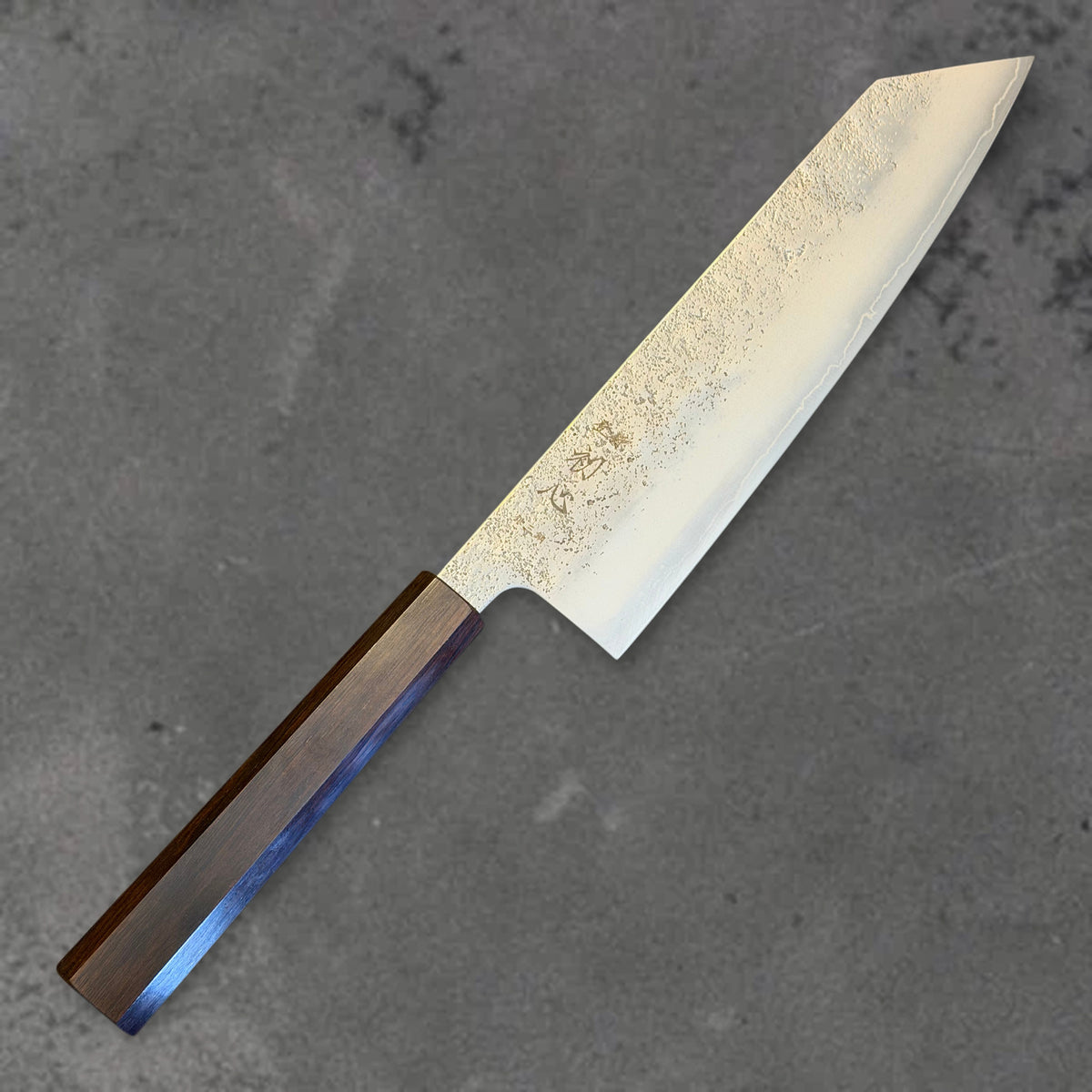 Angled front view of the Hatsukokoro Ginrei Ginsan Nashiji 210mm kiritsuke with ebony handle, showing the blade shape, finish, and handle.