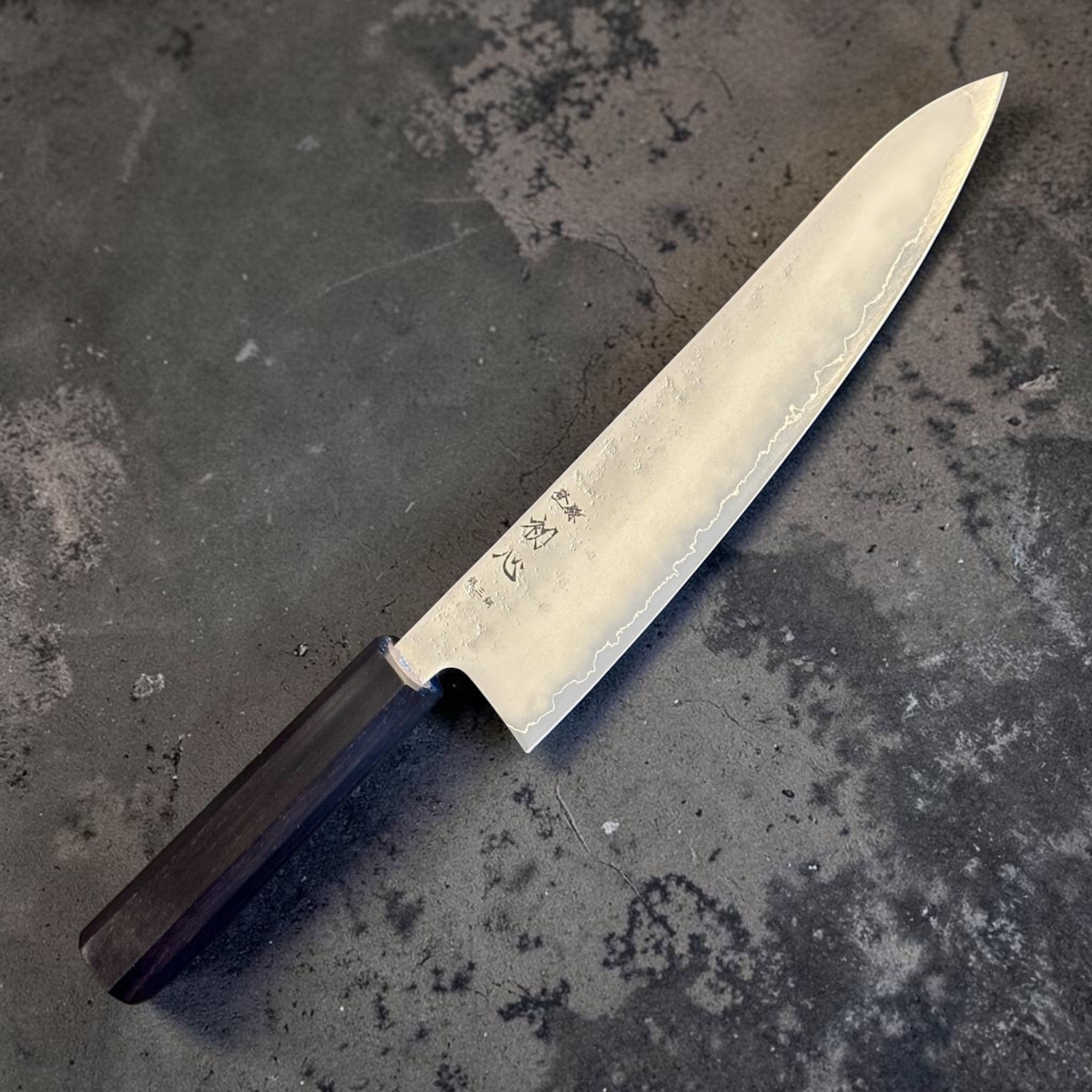 Hatsukokoro Ginrei Silver #3 Gyuto 210 mm with mono ebony handle, reverse angled blade view with maker mark.