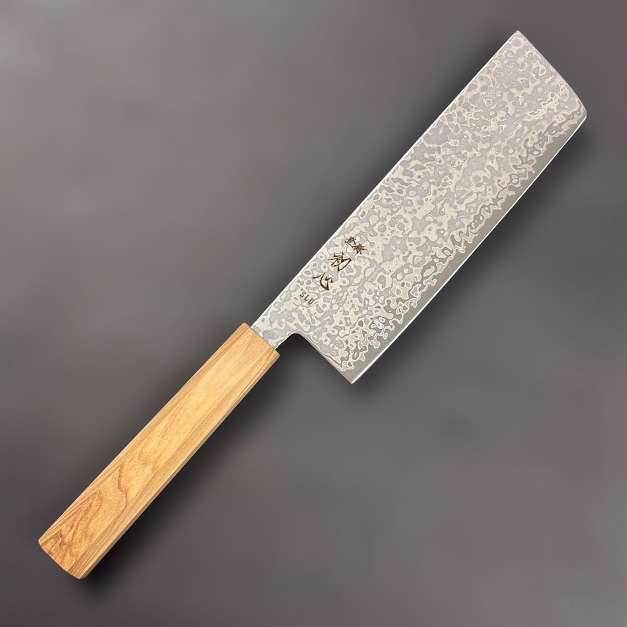 Hatsukokoro Hikari SLD Damascus Nakiri 160 mm with olive wood handle, angled hero shot.