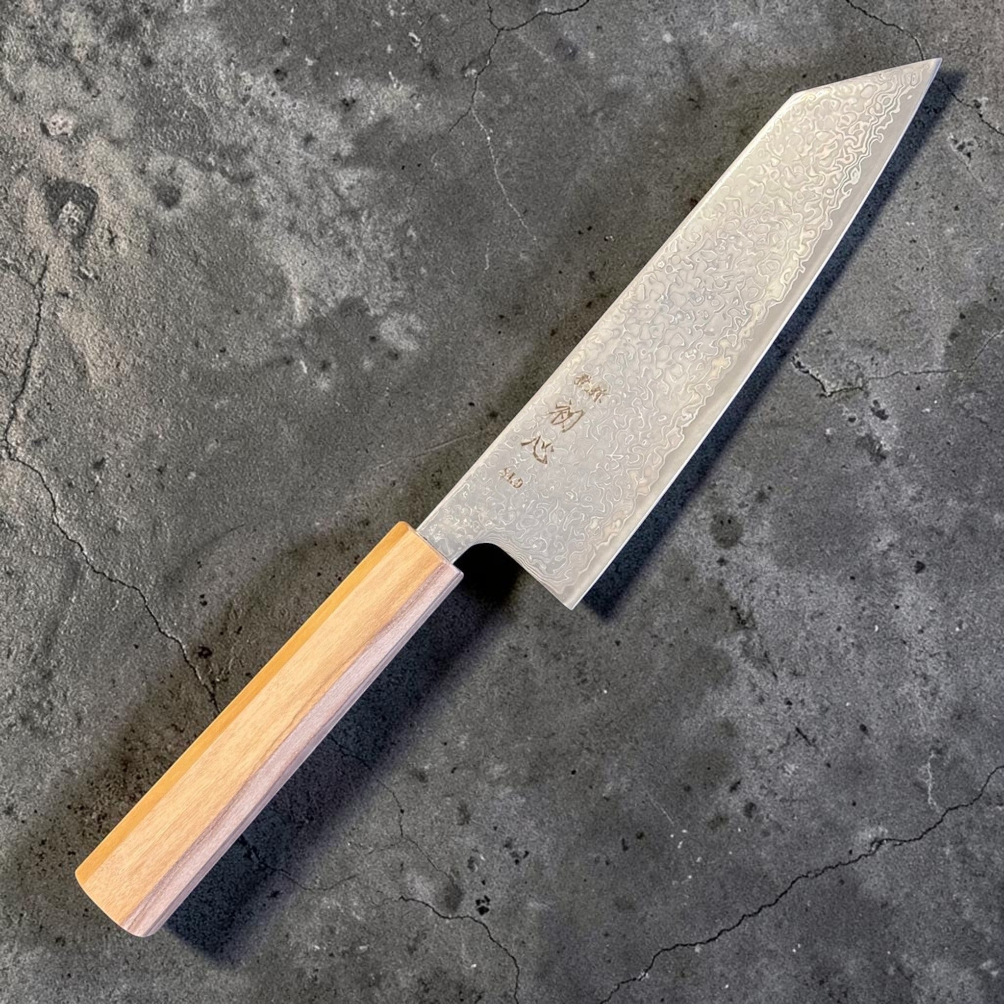 Hatsukokoro Hikari SLD Damascus Kurozome Bunka 170 mm with olive wood handle, angled front view of the full knife.