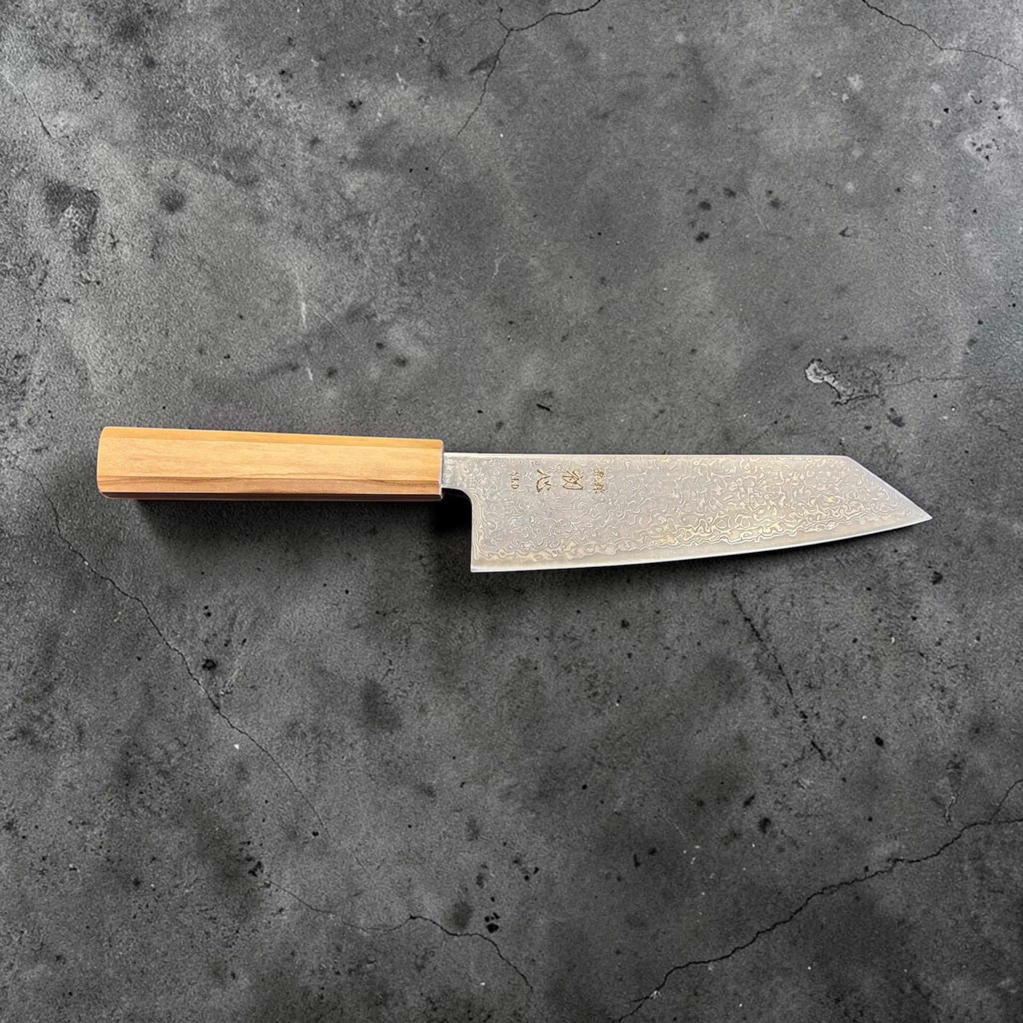 Hatsukokoro Hikari SLD Damascus Kurozome Bunka 170 mm with olive wood handle, full profile view with blade facing right.