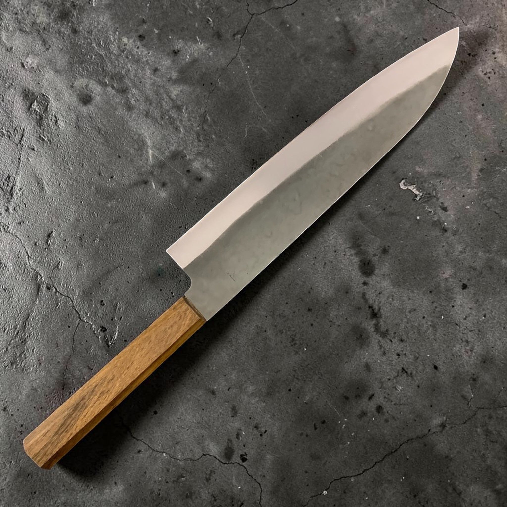 Hatsukokoro Hinomaru White #2 Kurouchi Gyuto 210 mm, left-side view showing kanji engraving, kurouchi finish, and octagonal wooden wa handle on a black background.
