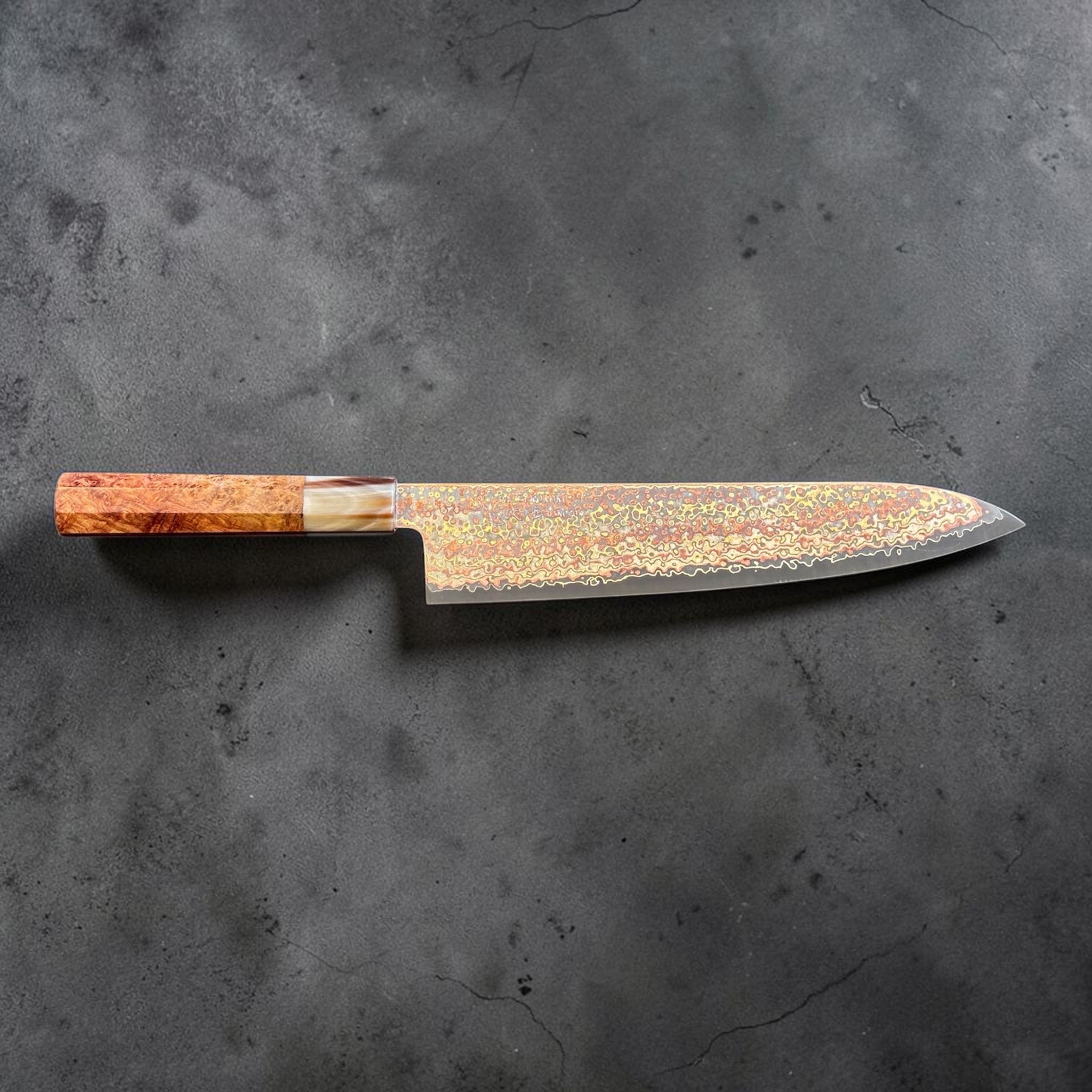 Hatsukokoro Hinotori V-Toku2 Rainbow Damascus Gyuto 240 mm with amboyna burl handle, full side profile on a gray background.