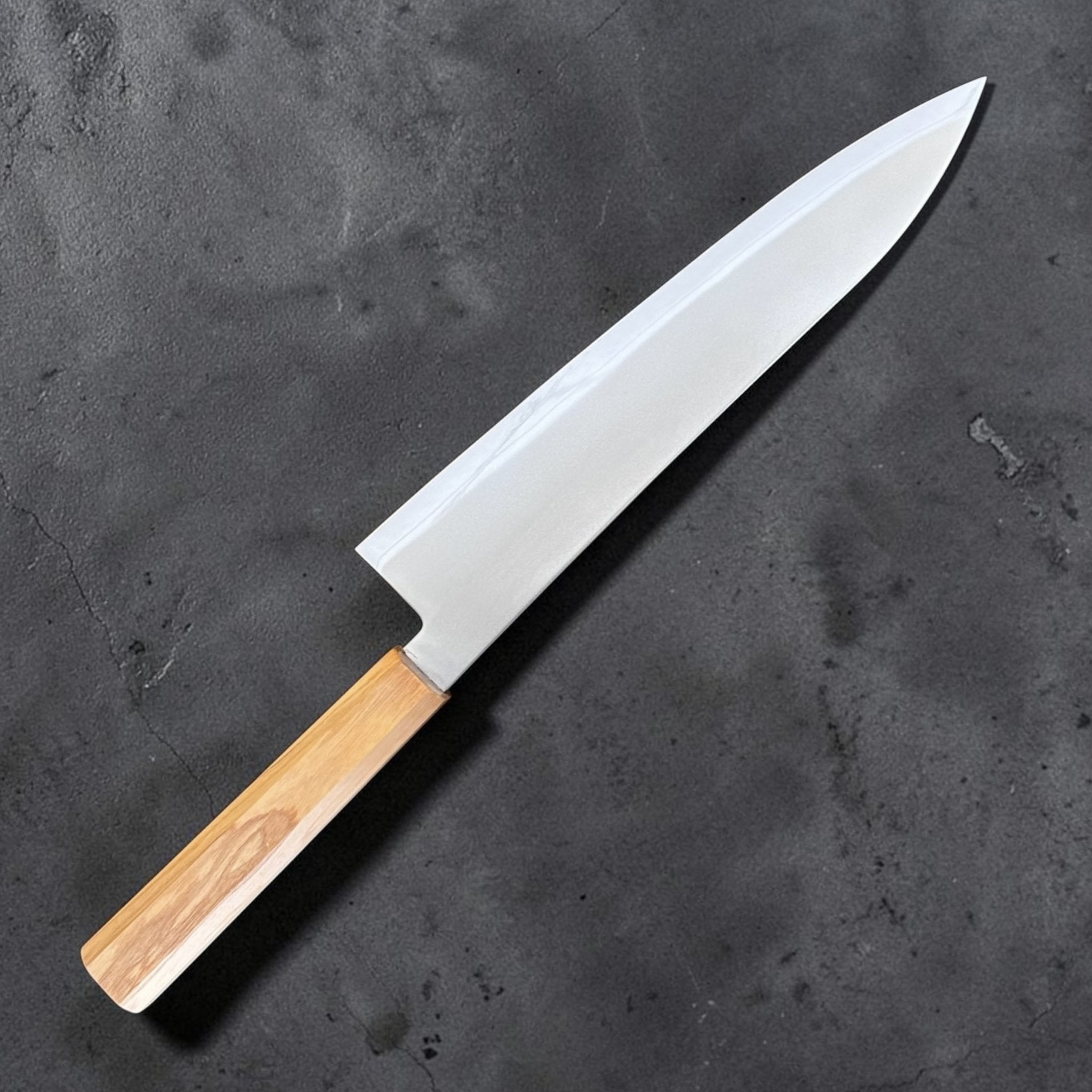 Hatsukokoro Kaijin Blue #2 Gyuto 210 mm with mono olive wood handle, clean angled blade view showing the grind and tip.