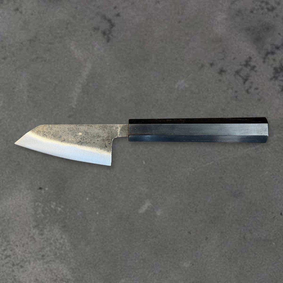 Hatsukokoro Kurogane Blue #2 Kurouchi 80mm ko-bunka with ebony handle, shown in horizontal reverse profile with the full blade and handle visible.