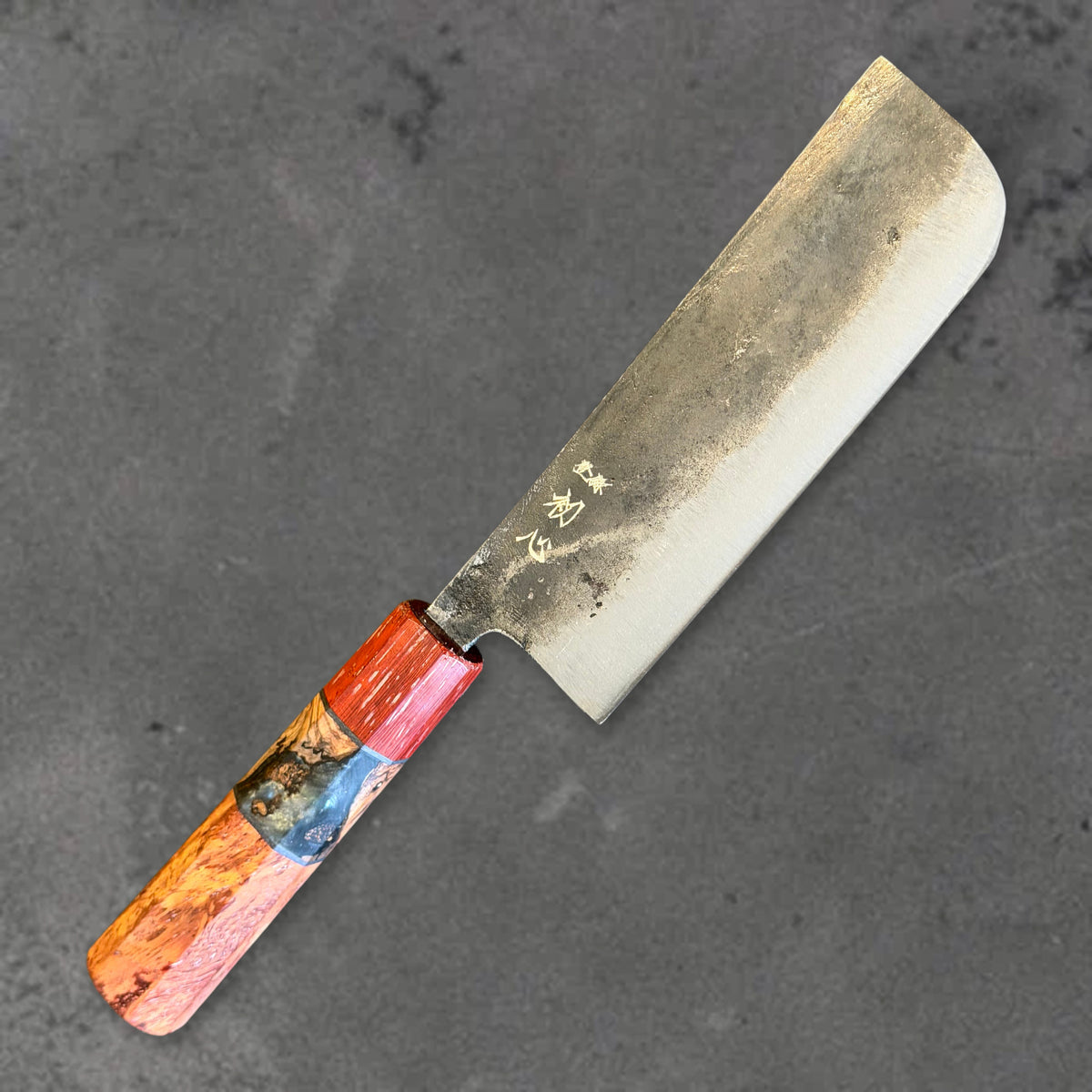 Angled front view of the Hatsukokoro Kurogane Blue #2 Kurouchi 120mm nakiri with Prisma handle, showing the blade shape, finish, and handle. #Handle_Prisma