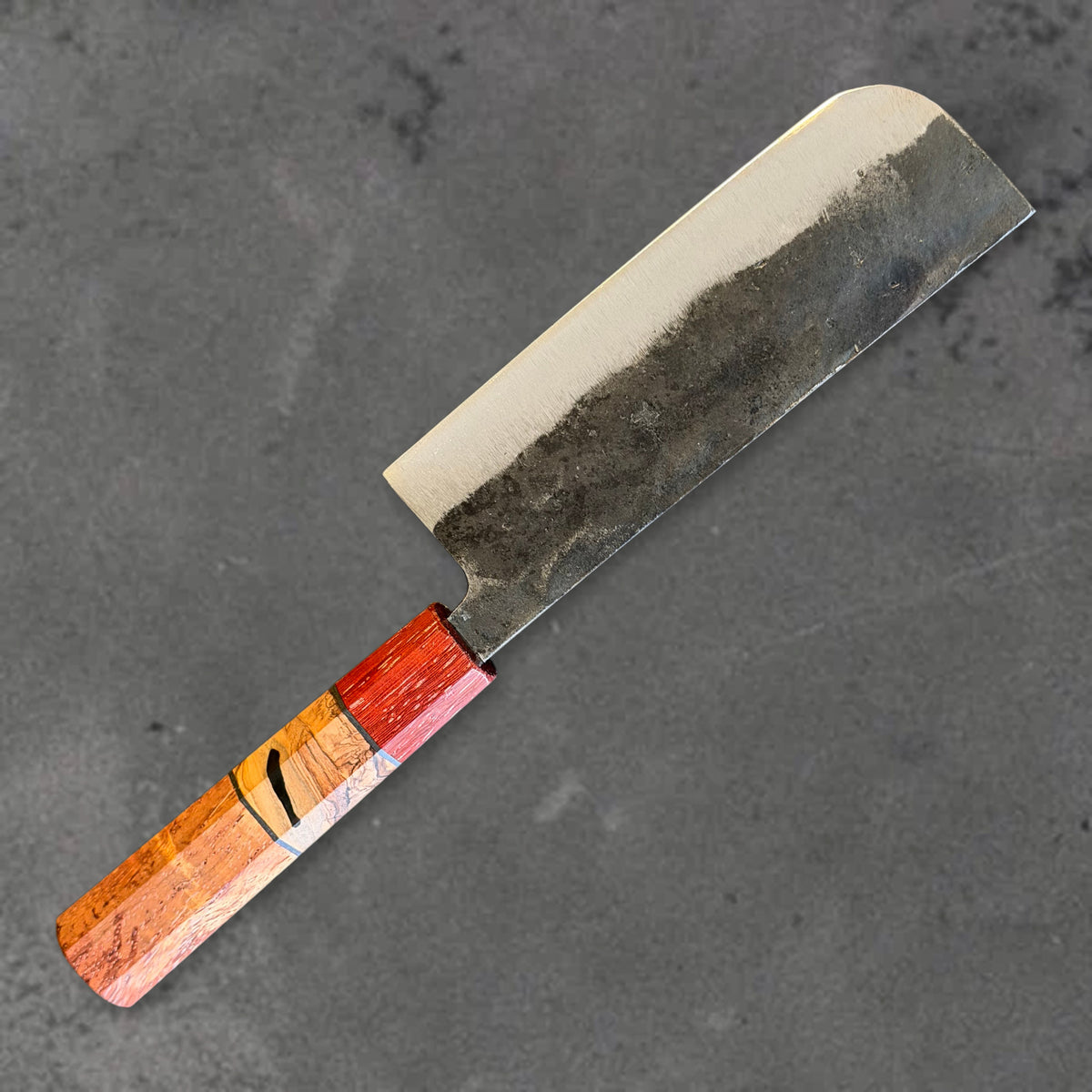 Angled reverse view of the Hatsukokoro Kurogane Blue #2 Kurouchi 120mm nakiri with Prisma handle, showing the blade shape, finish, and handle. #Handle_Prisma