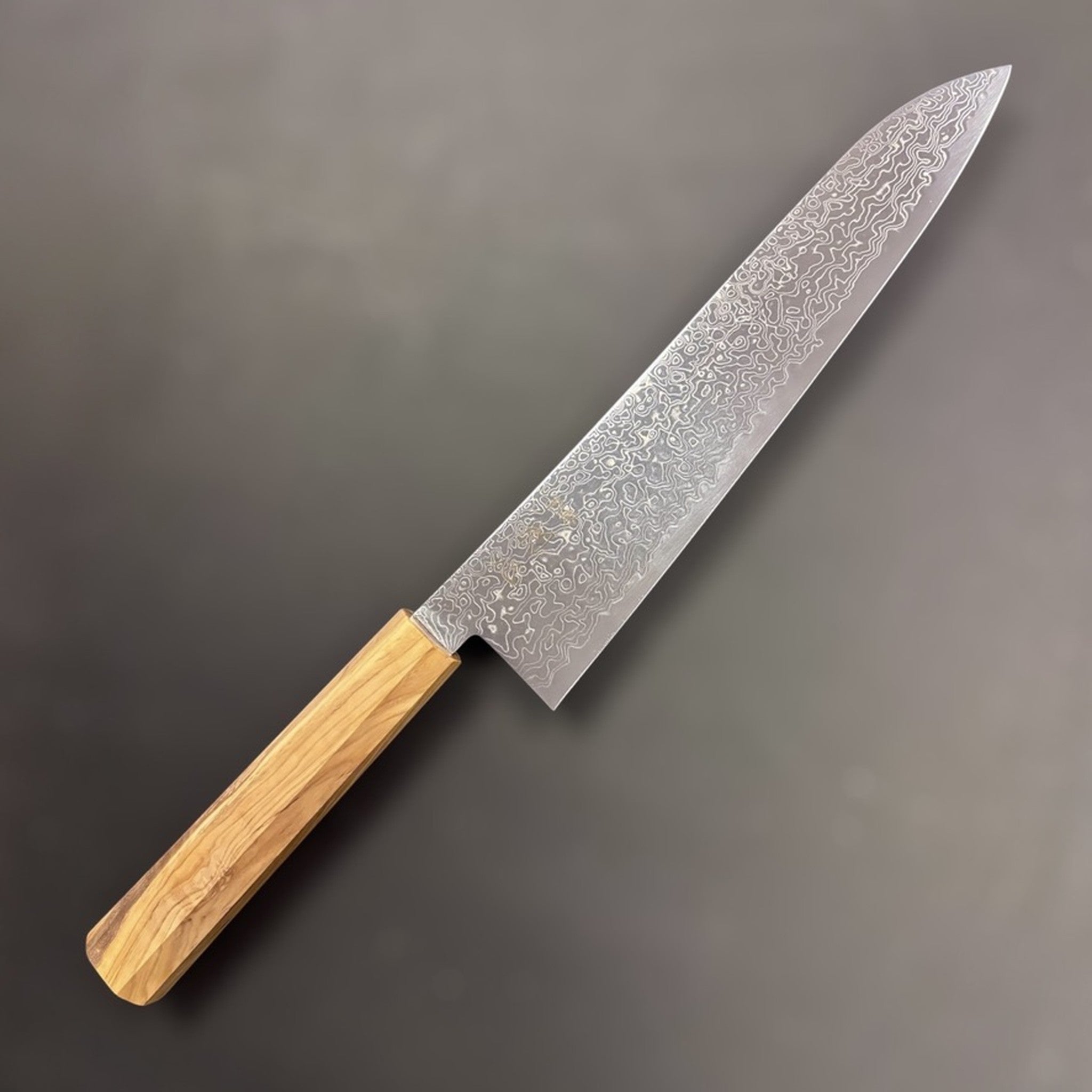 Hatsukokoro Ryuhyo SG2 Damascus Gyuto 240 mm, front view displaying the swirling Ryuhyo Damascus pattern and olivewood wa handle.