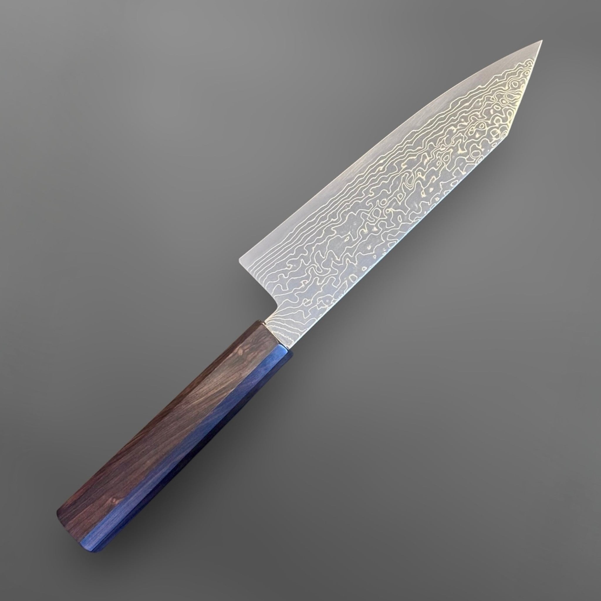 Hatsukokoro Ryuhyo SG2 Damascus Migaki Bunka with Mono Ebony Handle, angled reverse view showing the Damascus cladding and mono ebony handle.