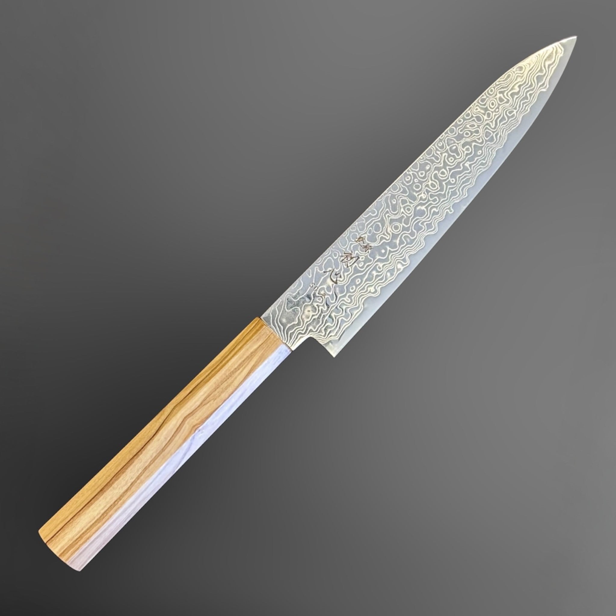Hatsukokoro Ryuhyo SG2 Damascus Petty 150 mm with olive wood handle, angled view highlighting the pointed petty profile and layered blade finish.