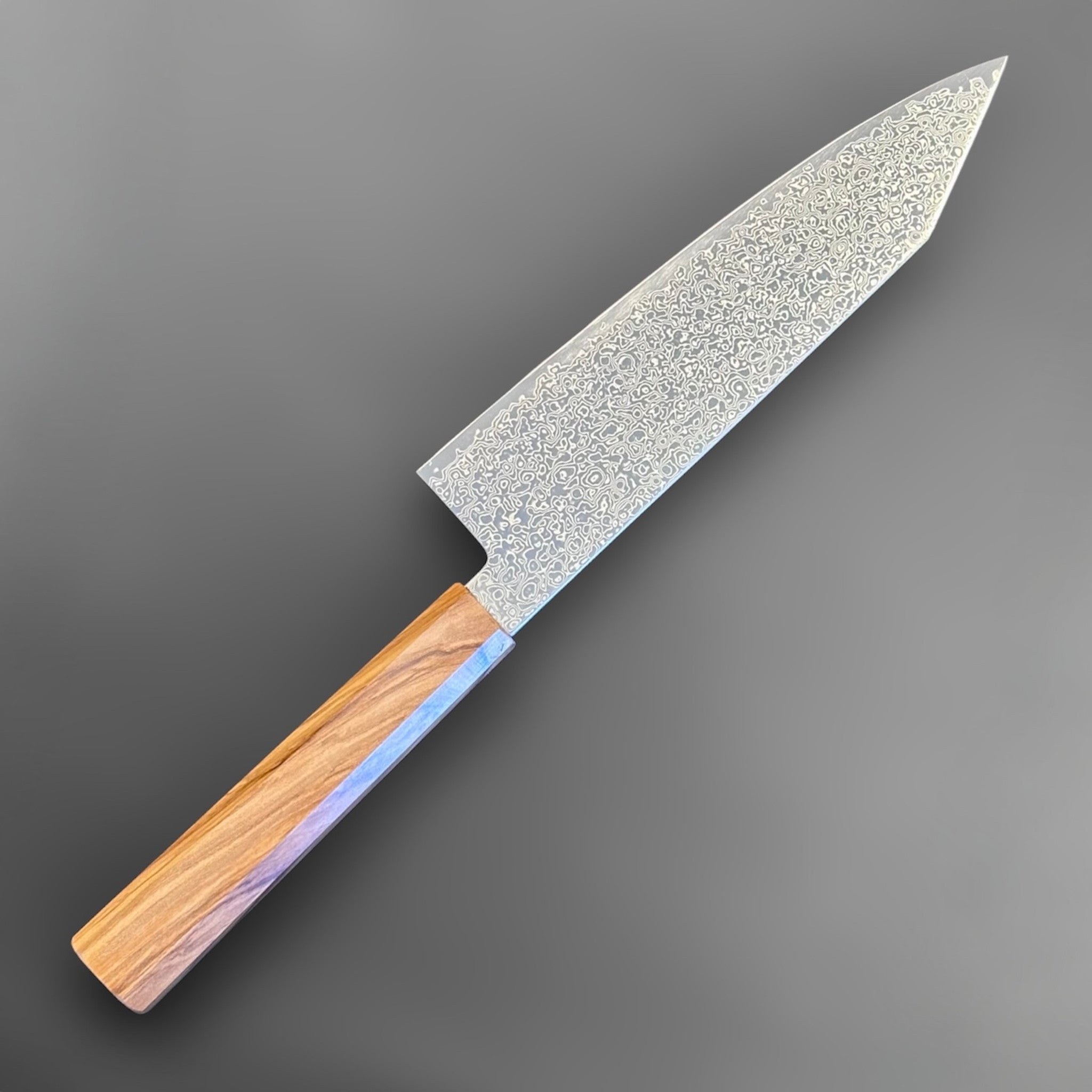 Hatsukokoro Saihyo SG2 Damascus Bunka 180 mm with olivewood handle, angled rear-side view showing the blade face and octagonal handle.