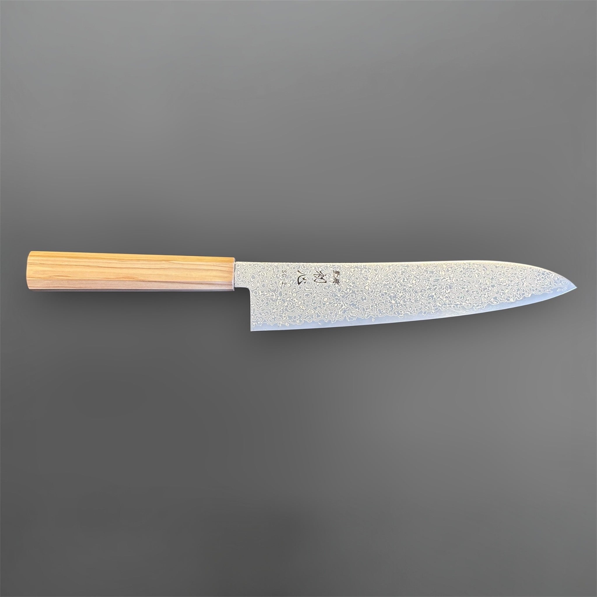 Hatsukokoro Saihyo SG2 Damascus Gyuto 210 mm with mono olive handle, side profile view showing the full blade, machi area, and etched Damascus finish.