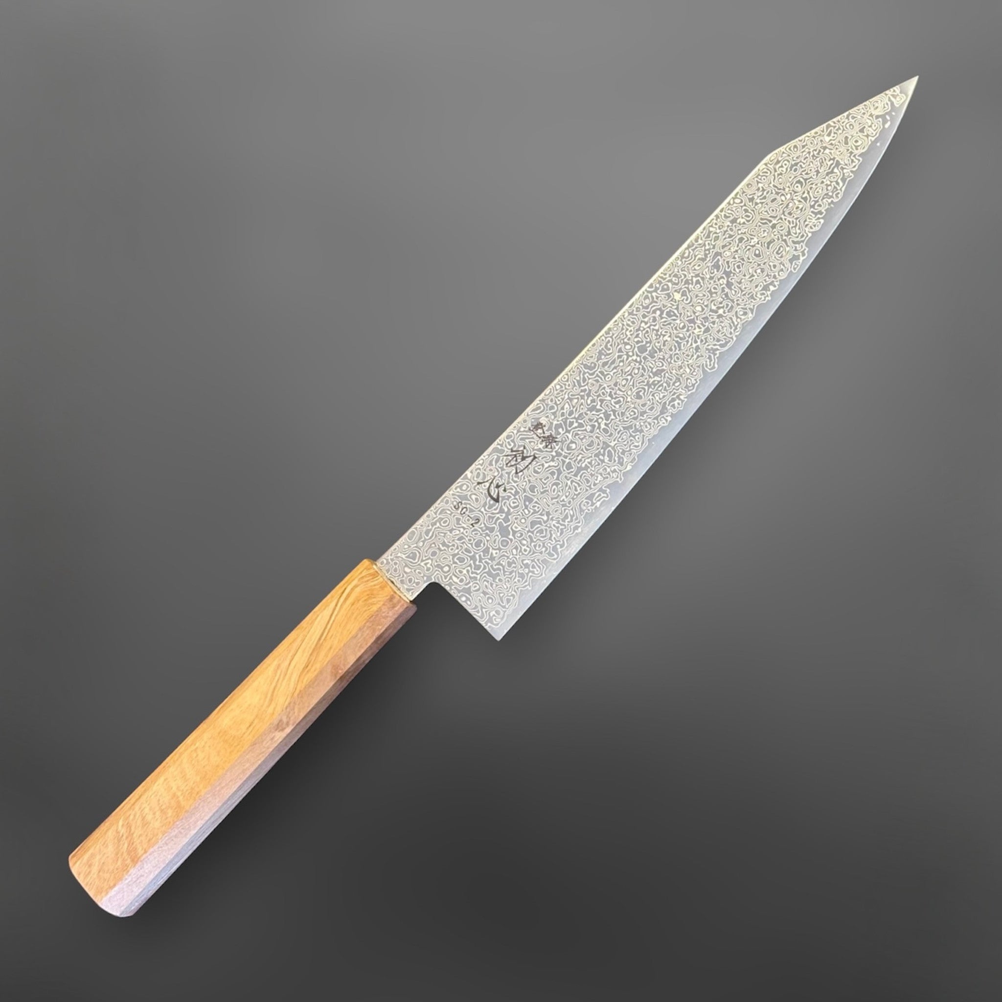 Hatsukokoro Saihyo SG2 Damascus Kiritsuke 210 mm with mono olive handle, angled logo-side view.