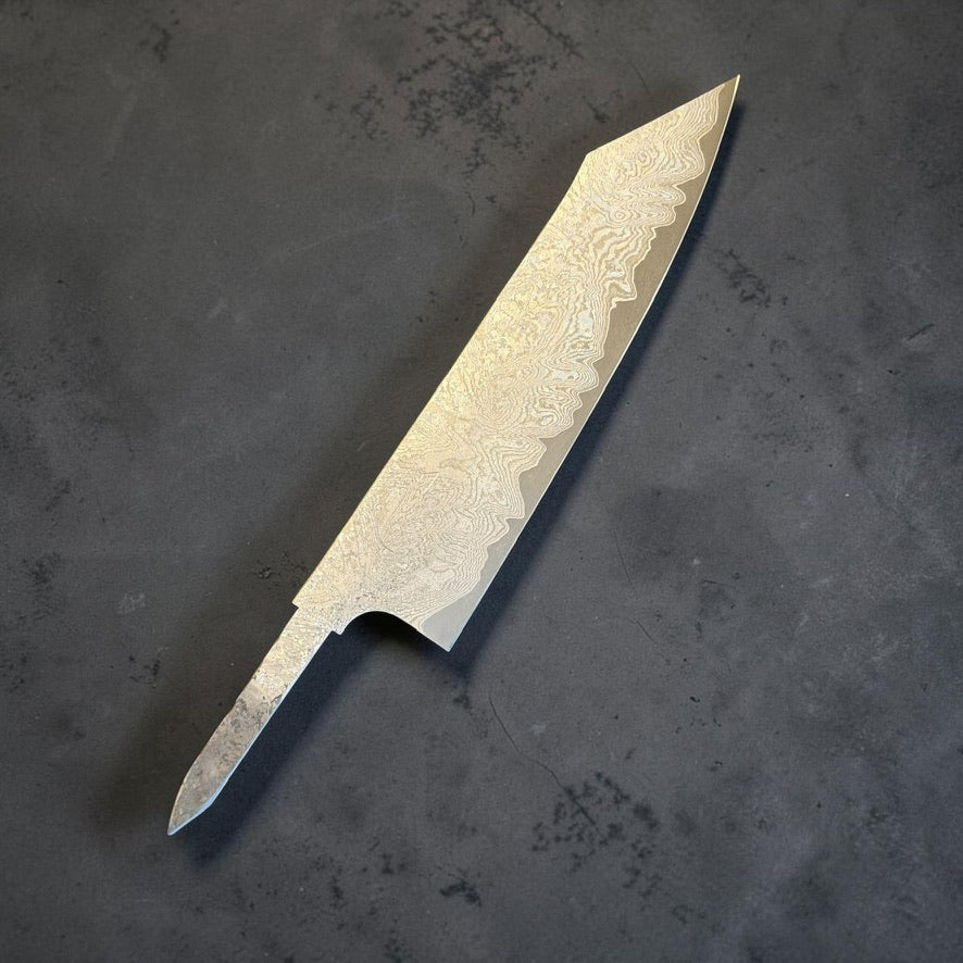 Angled front view of the Hatsukokoro VG-XEOS Kurozome Damascus Kiritsuke Gyuto 210mm blade, showing the k-tip and exposed tang.