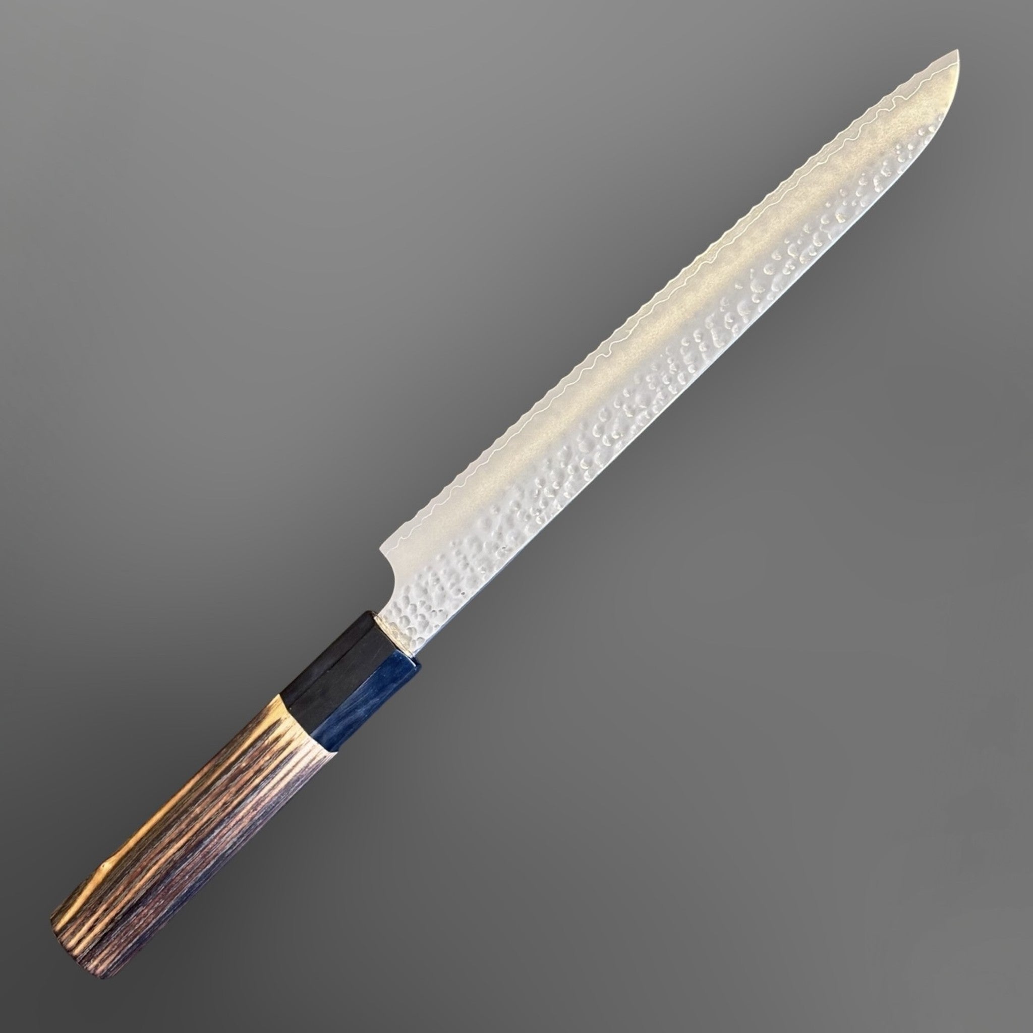 Hatsukokoro VG-10 Tsuchime Serrated Bread Knife 230 mm with burnt wood and black buffalo horn handle, angled product view showing the full blade profile, burnt wood handle, and black buffalo horn ferrule.