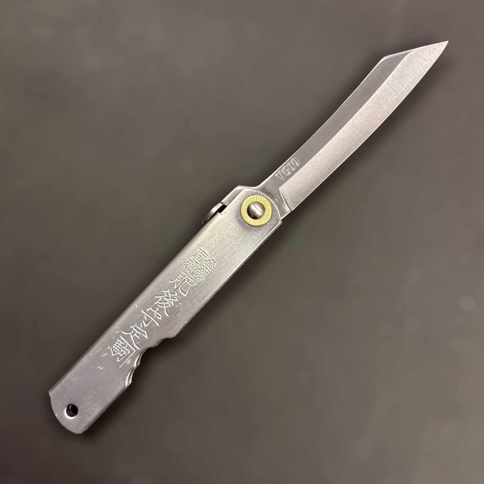 Front view of Higonokami VG-10 pocket knife showing kanji engraving on handle.