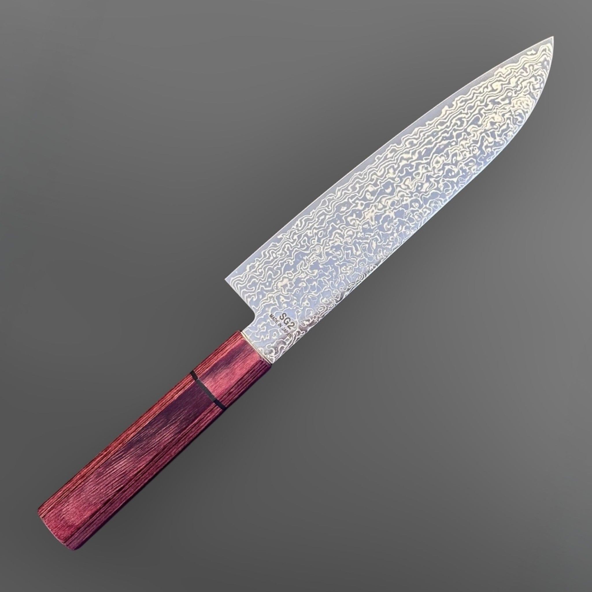 Higuchi SG2 Damascus Santoku 180 mm with red pakkawood handle, full knife angled view showing the Damascus blade pattern.