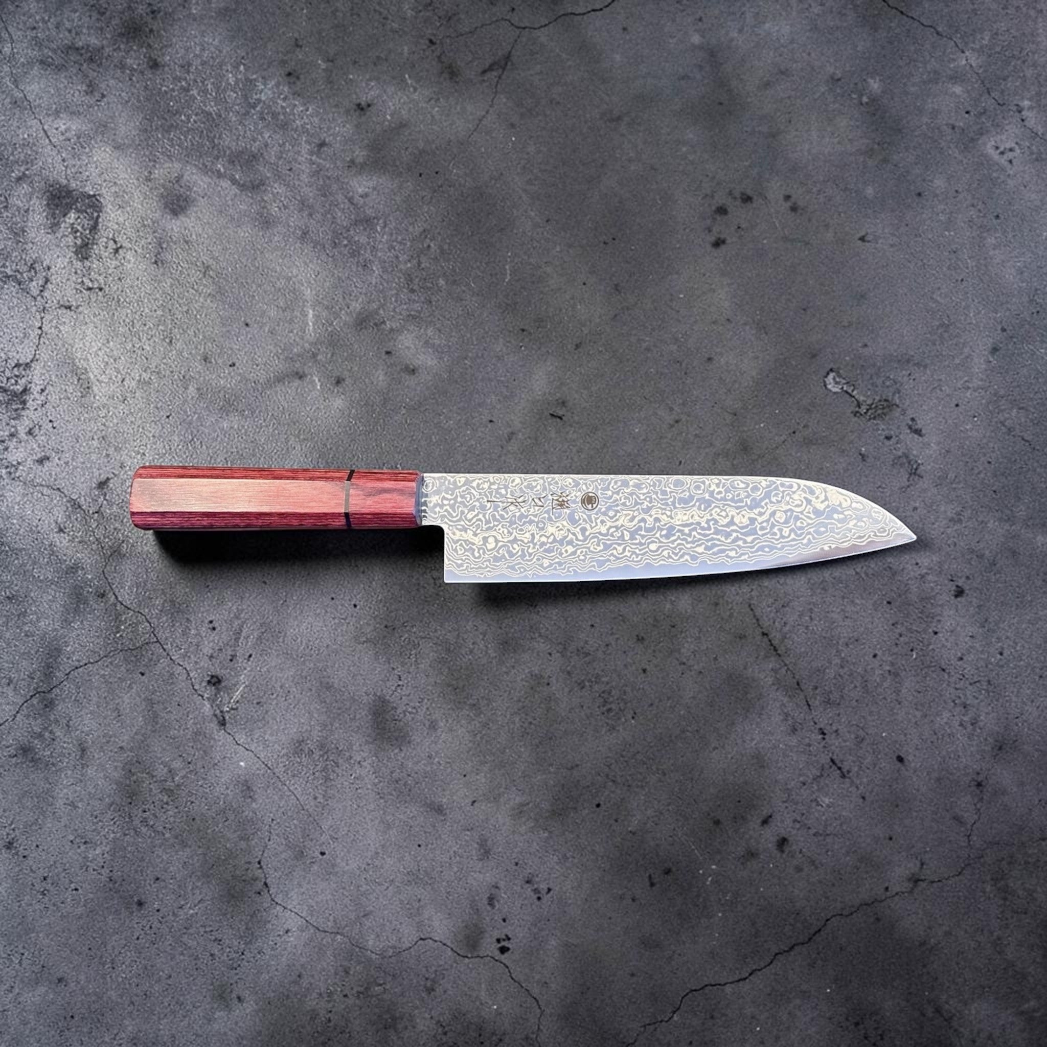Higuchi SG2 Damascus Santoku 180 mm with red pakkawood handle, horizontal profile view showing blade shape and handle.