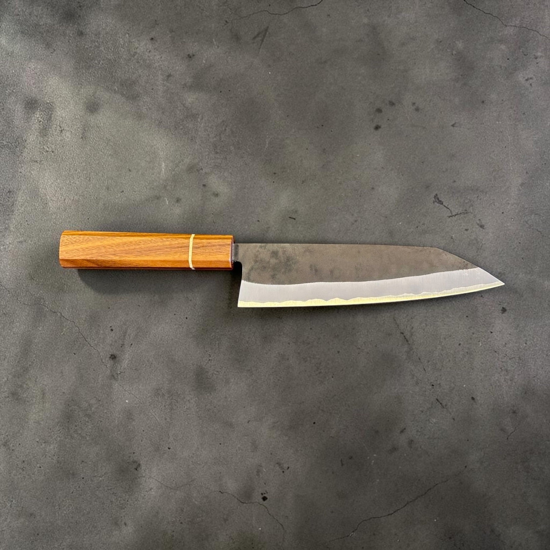 Reverse profile of the Imai Stainless Clad Aogami Super Kurouchi Bunka 183 mm highlighting the kurouchi finish and handcrafted Sanjo walnut handle.