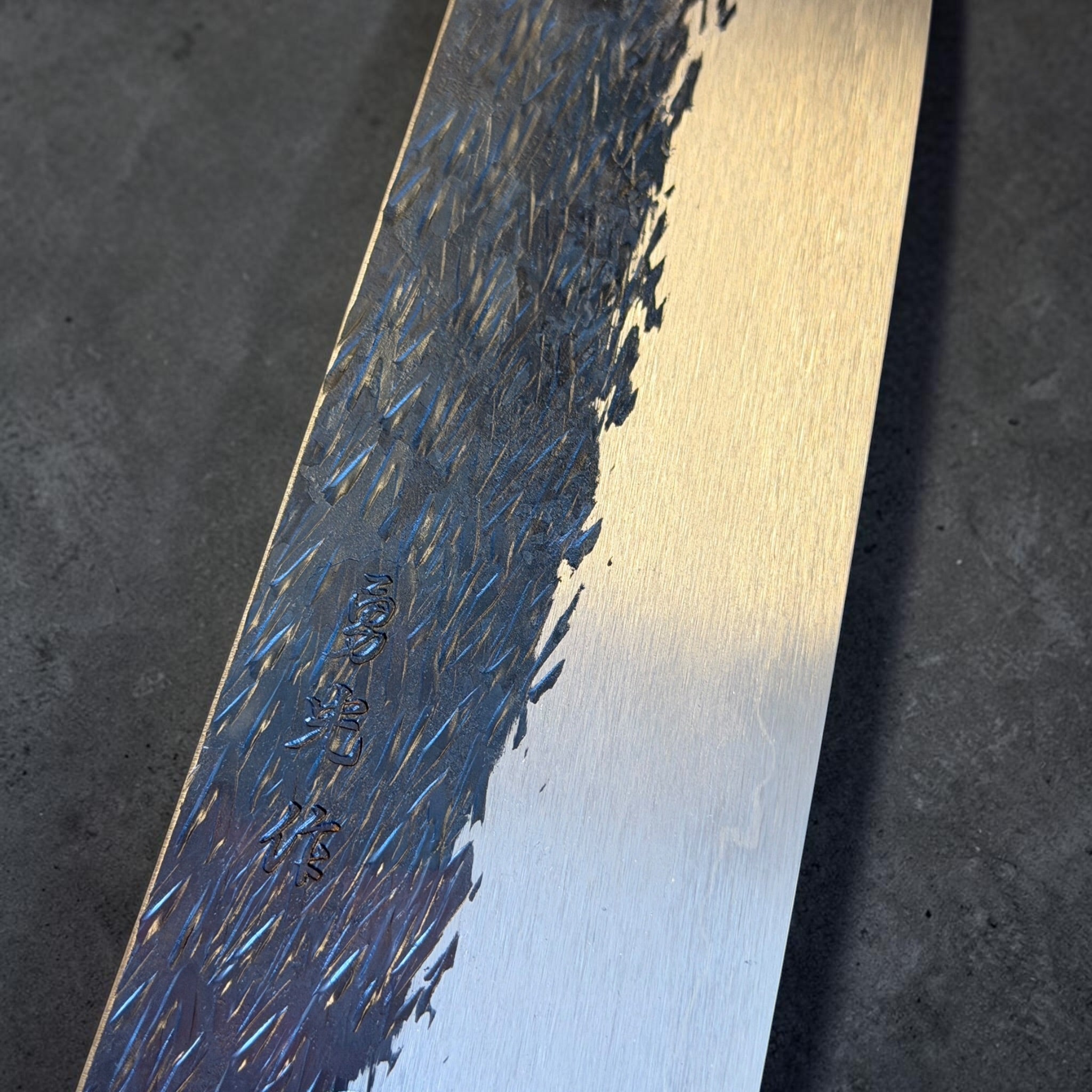 Isamitsu gyuto kurouchi tsuchime finish and kanji close-up