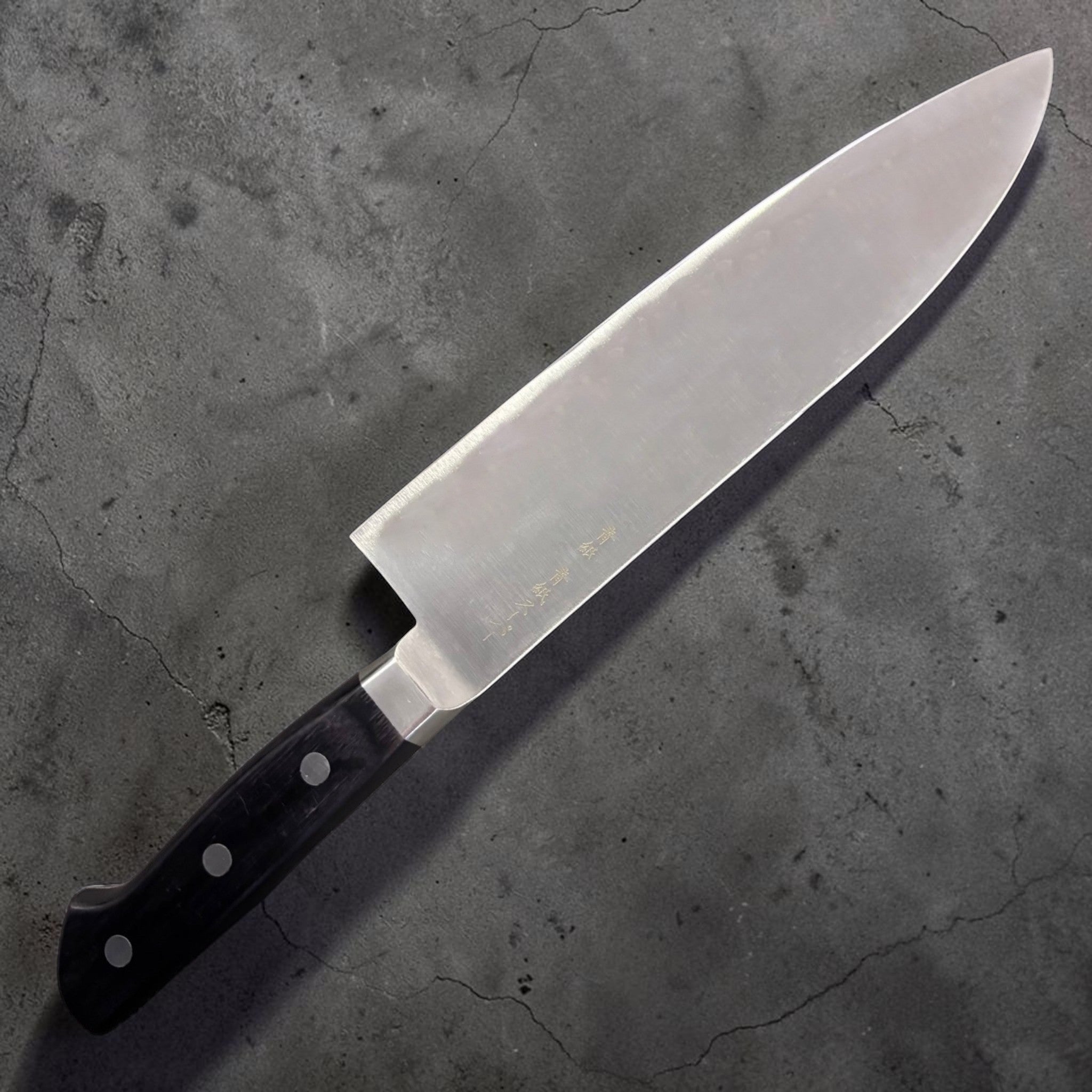 Ittetsu AS Santoku 180 mm, three-quarter hero angle showing kanji and belly curve.