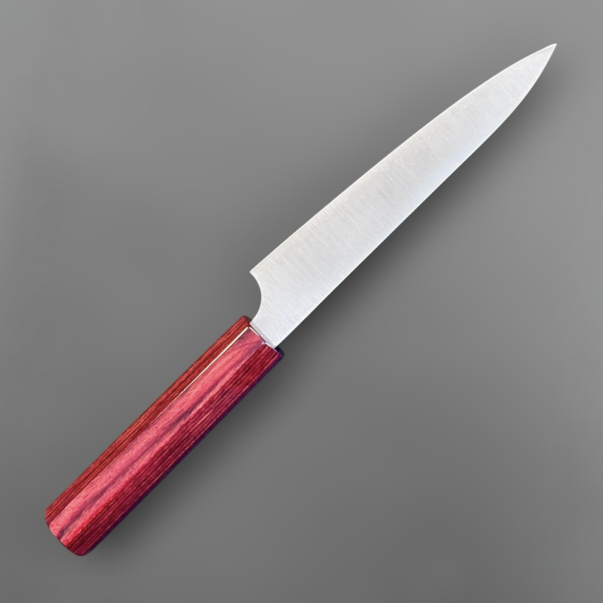 Kei Kobayashi SG2 Migaki petty knife with red wa handle, angled beauty shot emphasizing the polished blade face and vivid red handle grain.
