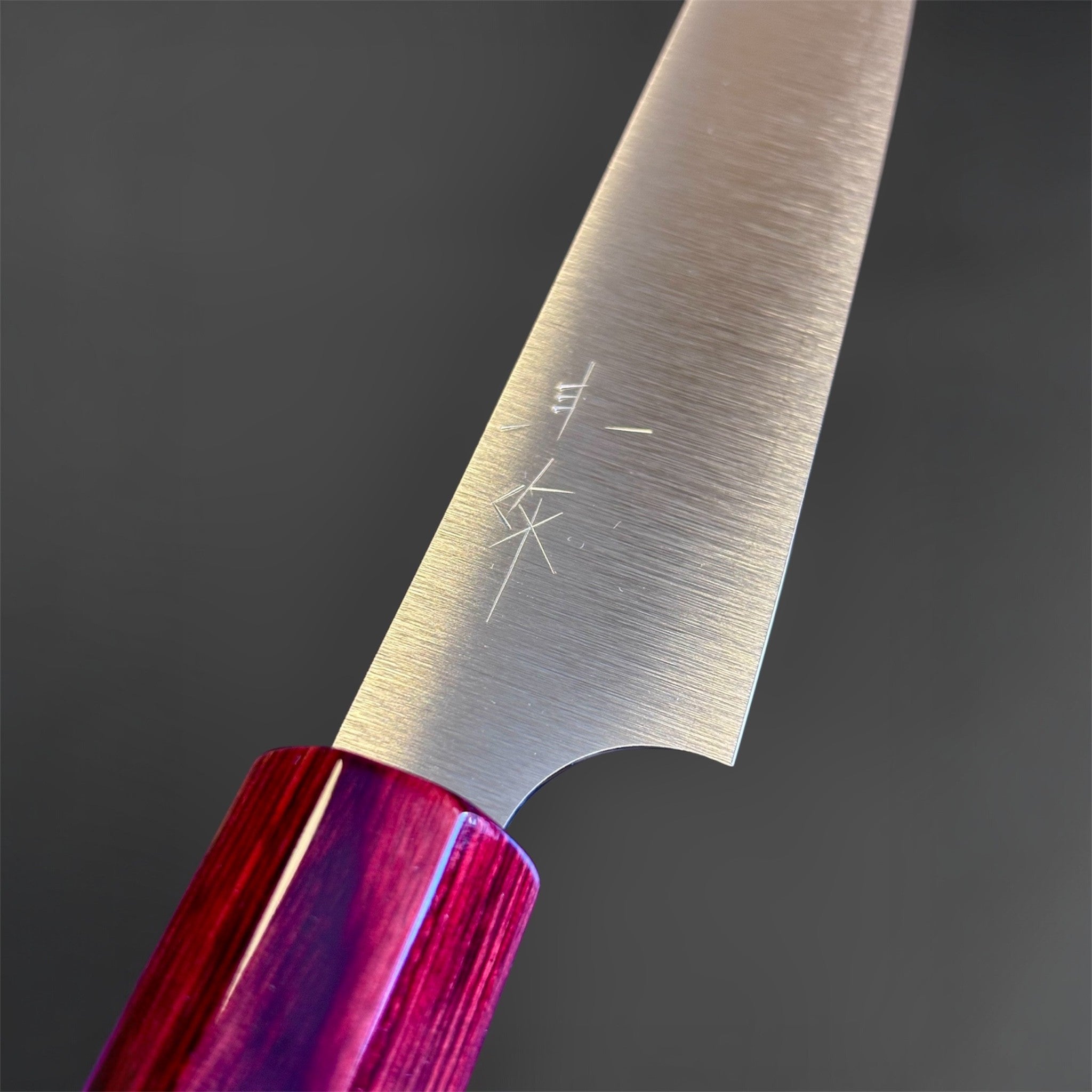 Kei Kobayashi SG2 Migaki petty knife with red wa handle, close-up of the heel and kanji engraving with the glossy handle junction in focus.