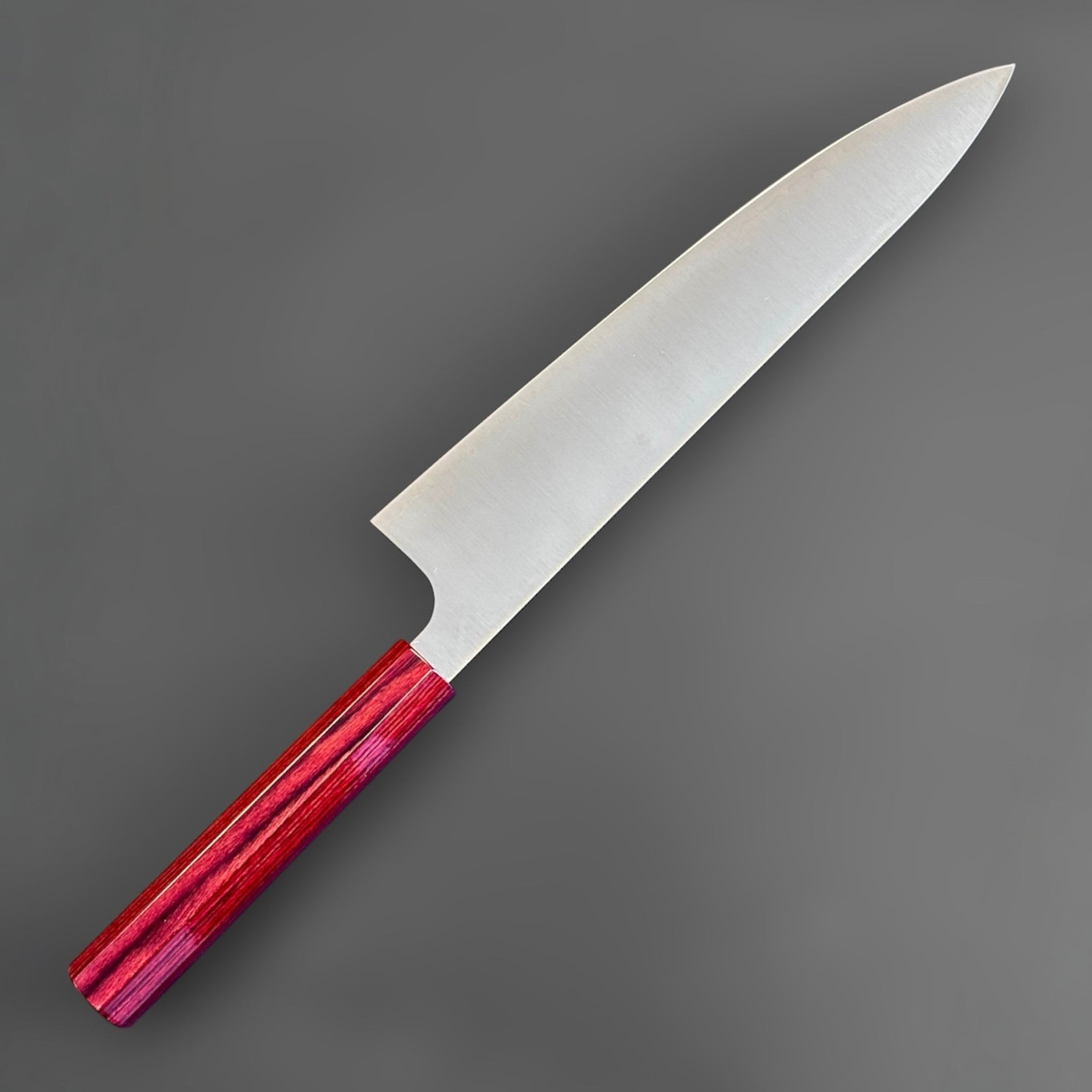 Kei Kobayashi SG2 Gyuto 210 mm with red lacquer handle, angled reverse-side view emphasizing the laser-thin profile and fine tip geometry.
