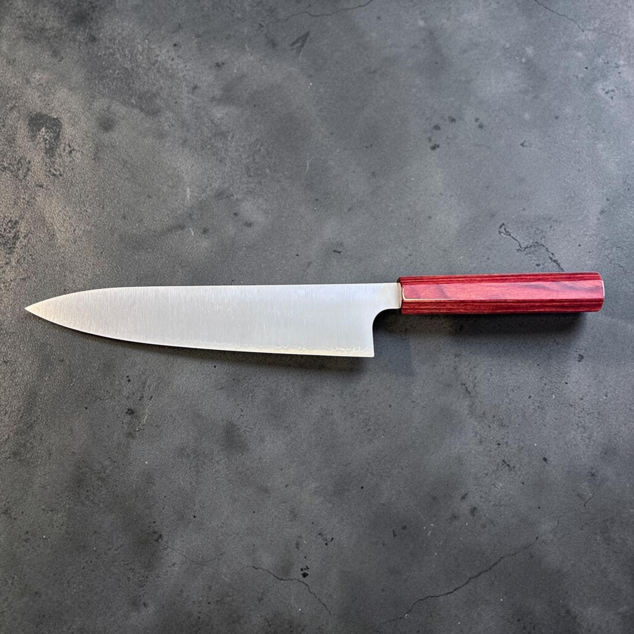 Kei Kobayashi SG2 Gyuto 210 mm with red lacquer handle, full reverse-side profile showing the sleek blade shape and polished finish.