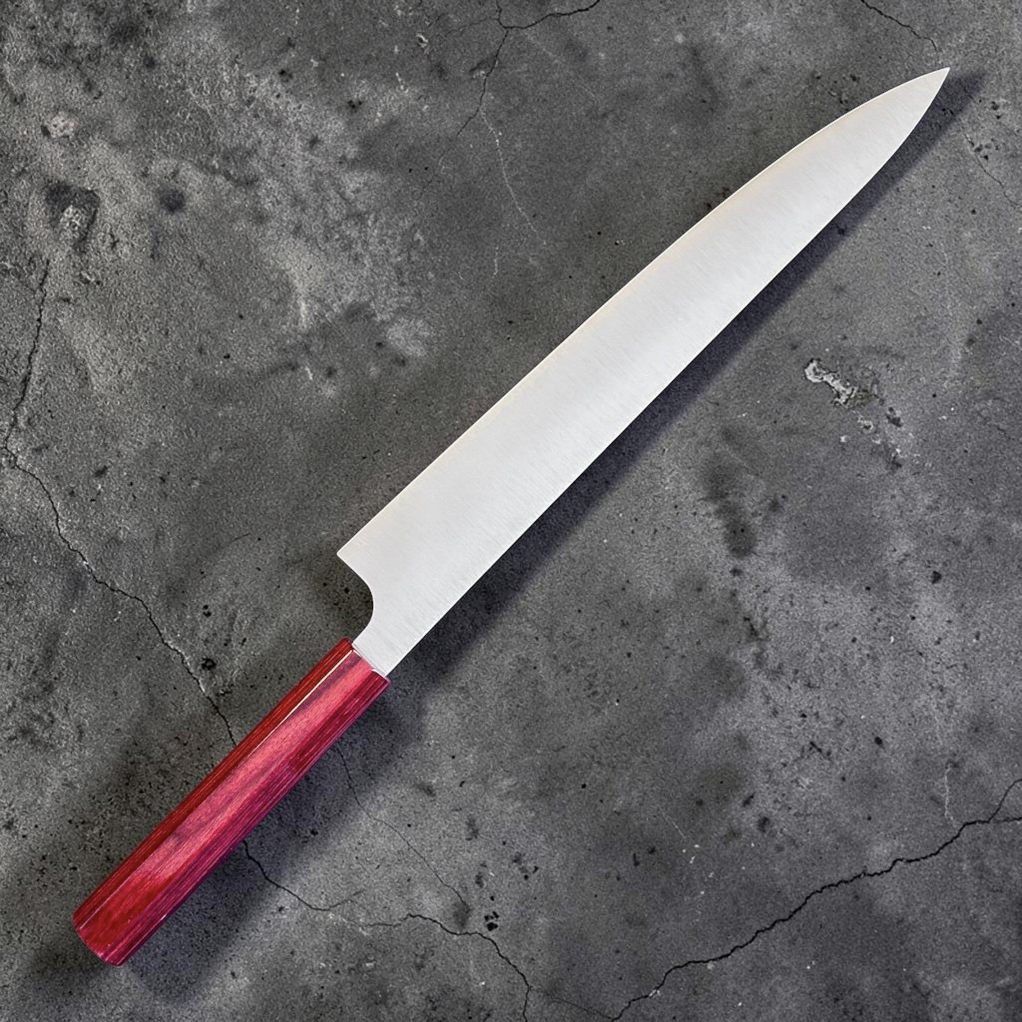 Kei Kobayashi SG2 Migaki Sujihiki 270 mm with red wa handle, angled reverse view showing the refined profile and satin blade finish.