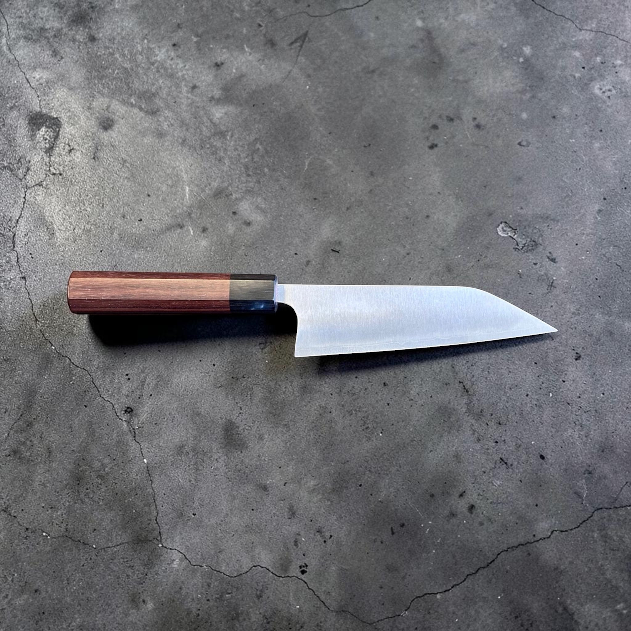 Koutetsu Chromax Santoku with rosewood octagon handle, full profile showing the tall santoku blade, kiritsuke-style tip, and octagonal handle.