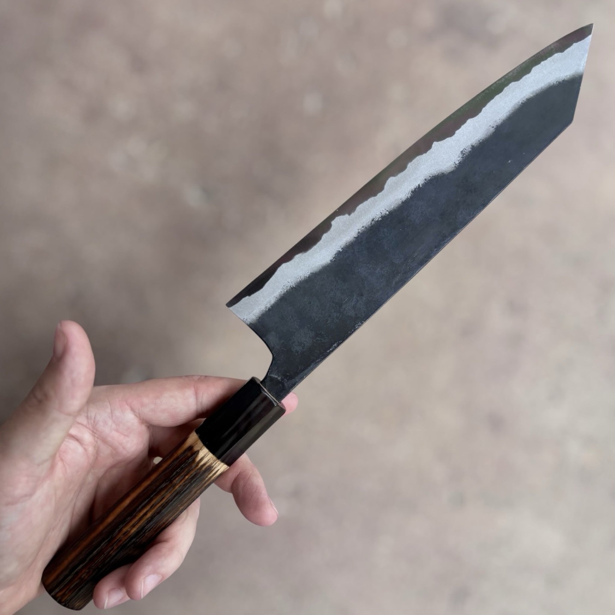 Kyohei Shindo Blue #2 Kurouchi Kiritsuke 210 mm with burnt wood handle and buffalo horn ferrule, choil view showing blade geometry.