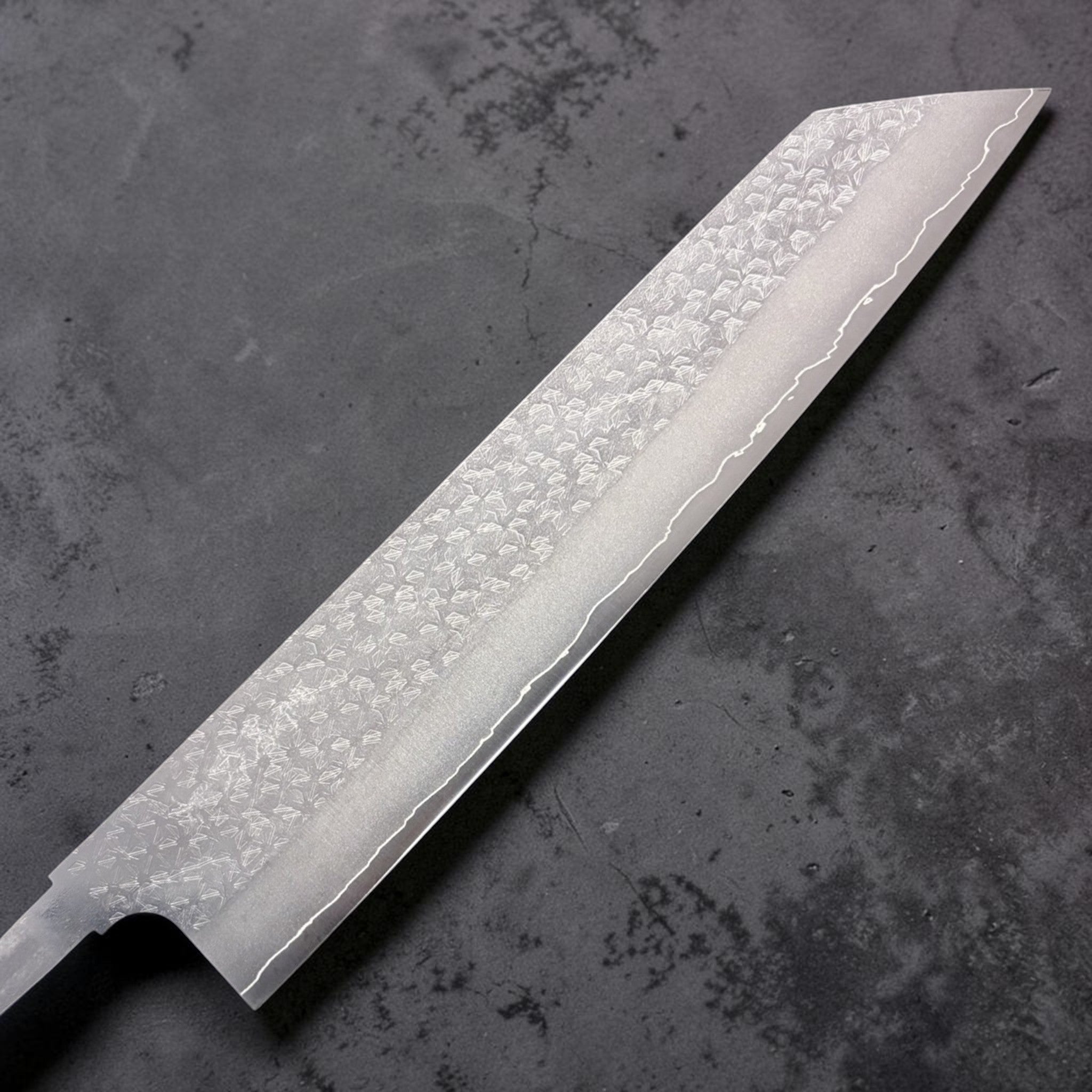 Makoto Kurosaki VG-XEOS Tsuchime Bunka 240 mm blade, close-up of hammered tsuchime pattern and hamon line toward the tip.