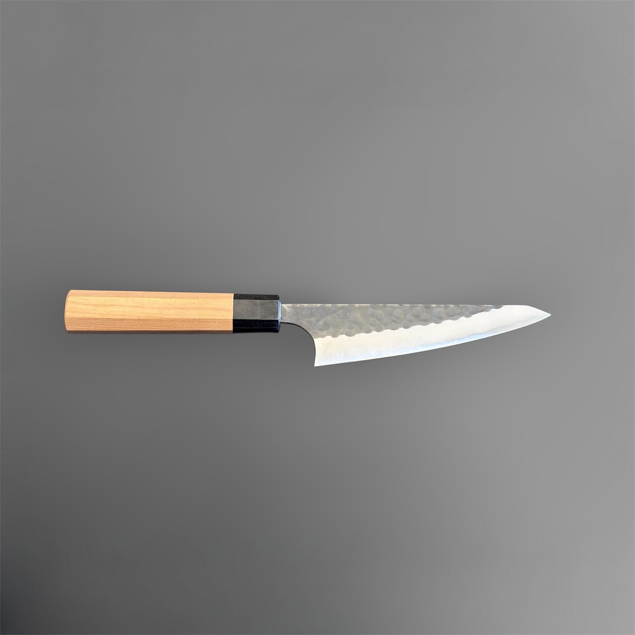 Masakage Koishi Honesuki Japanese knife, full side profile showing the blade shape, edge line, and light wood handle.