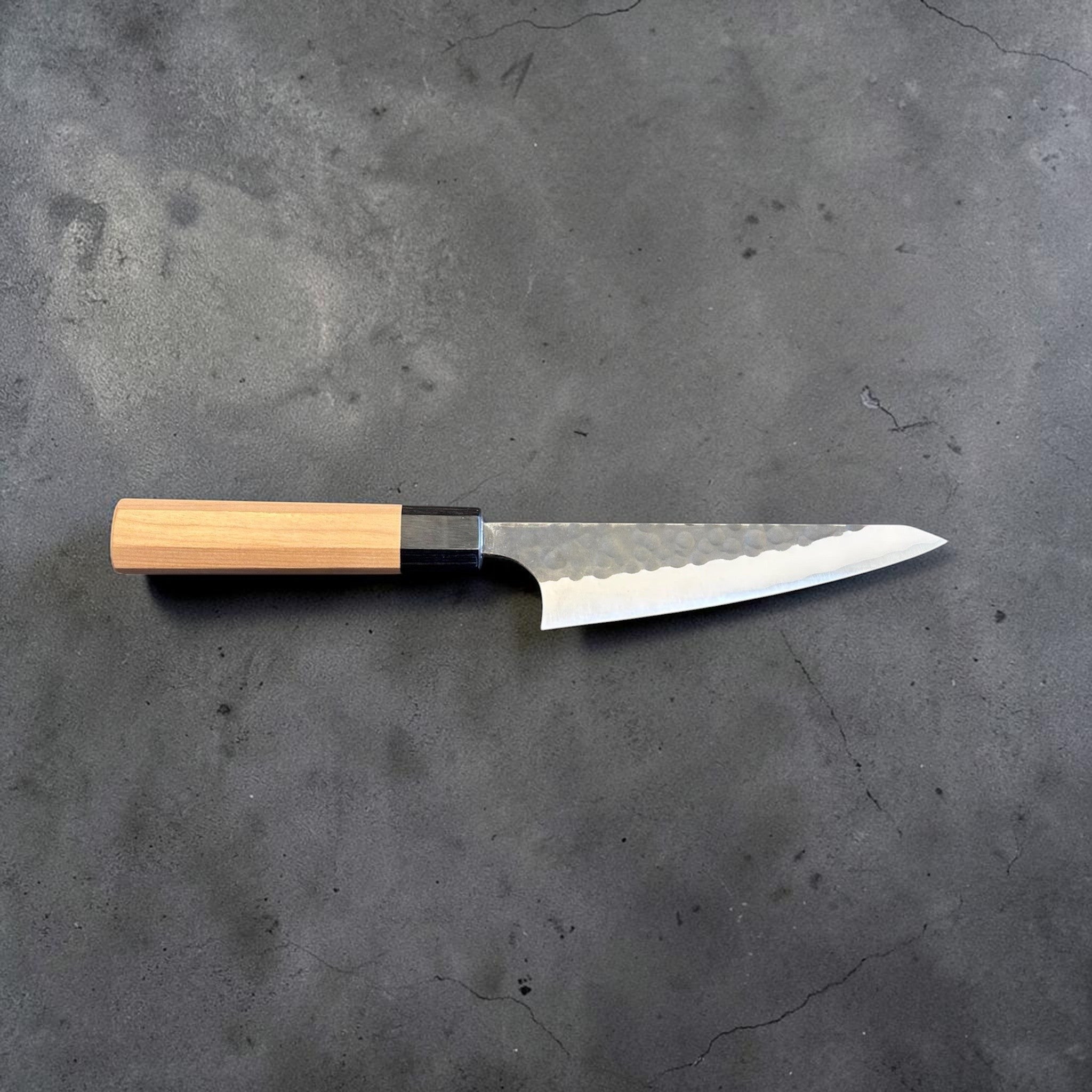 Masakage Koishi Honesuki Japanese knife, full side profile showing the blade shape, edge line, and light wood handle.