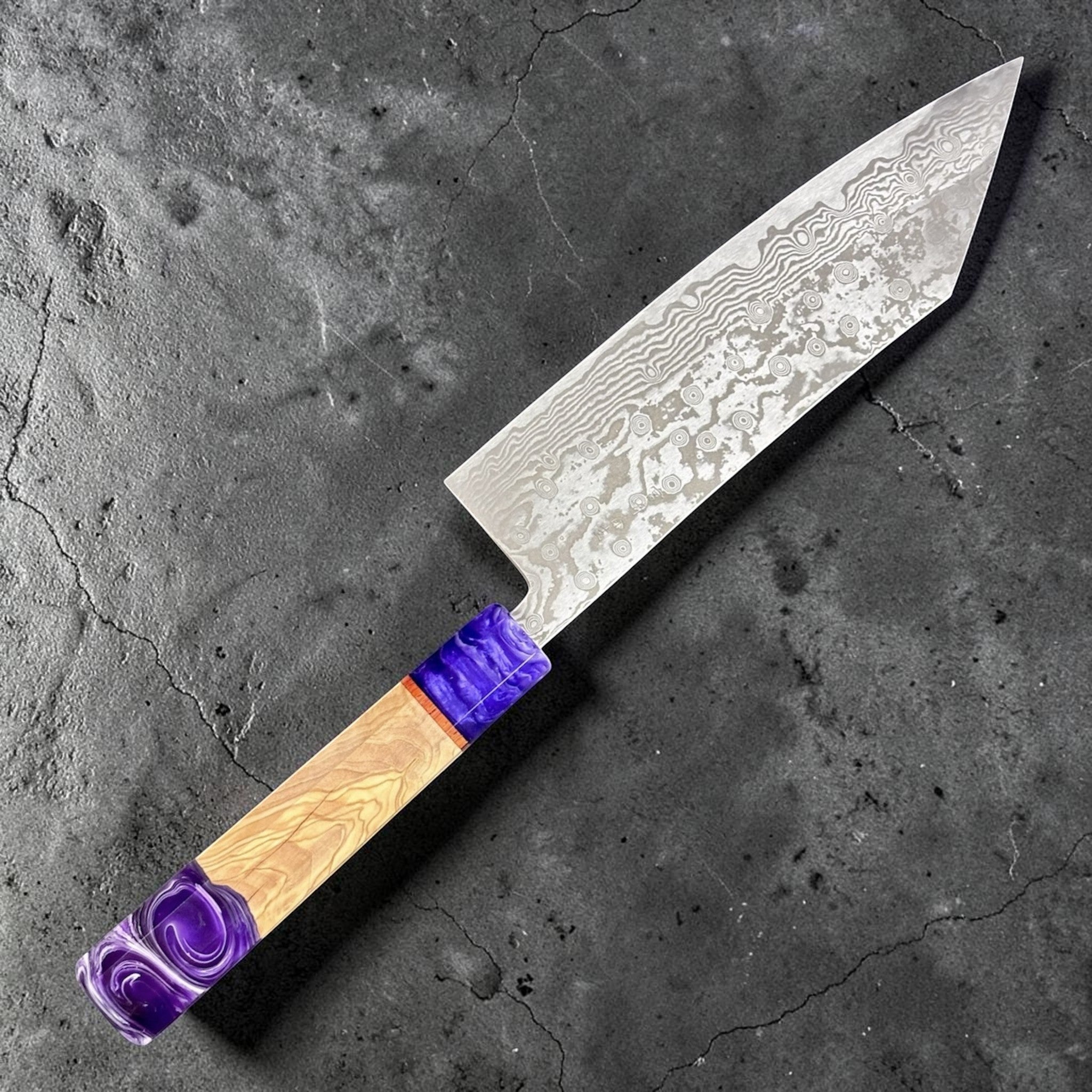 Miyazaki Kajiya ATS-34 Damascus Tsubaki 220 mm with Prisma knife handle, angled full-knife view showing the Damascus blade pattern and purple handle accents.