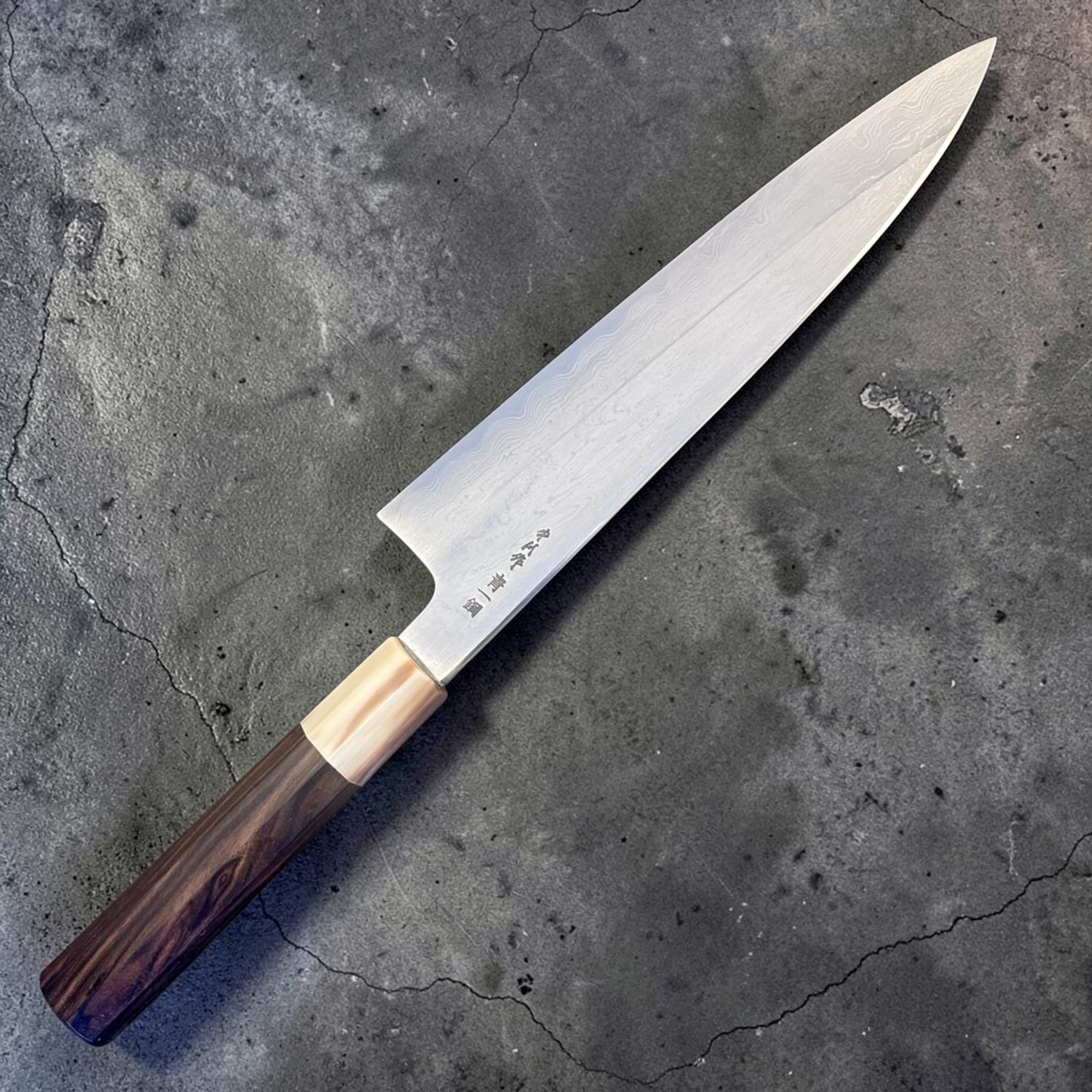 Nakagawa Satoshi Blue #1 Damascus Gyuto 225 mm with ebony and horn handle, angled full-length product view.