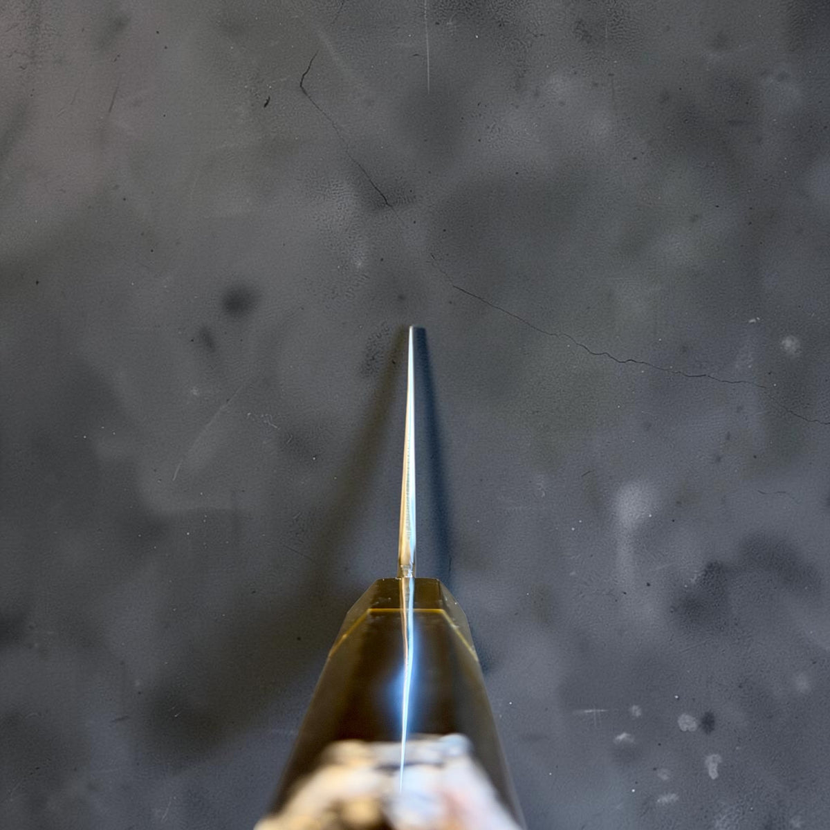 End-on choil view of the Nakagawa White #2 honyaki gyuto showing the blade grind above the Prisma handle