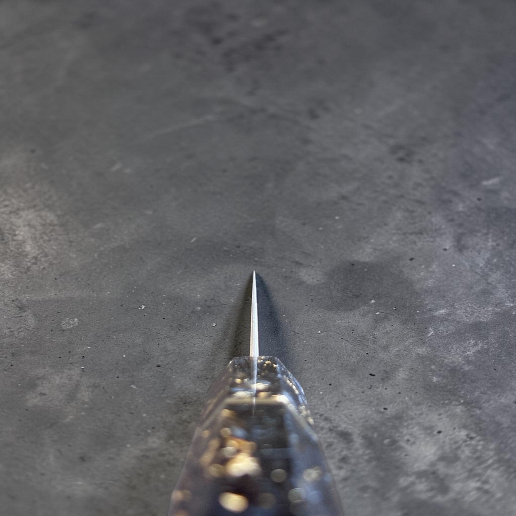 Nigara Anmon SG2 Petty 120 mm with carbon fiber and gold fleck handle, spine view showing the thin edge profile.