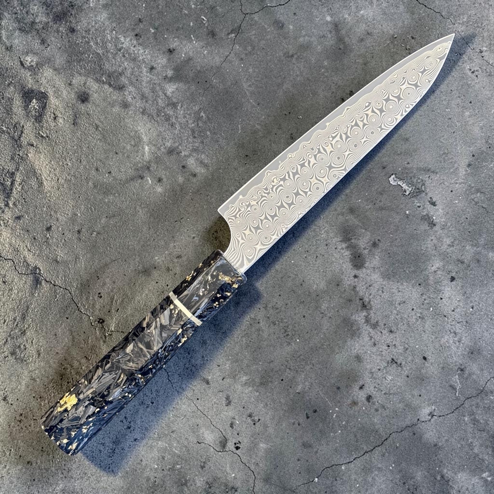 Nigara Anmon SG2 Petty 150 mm with carbon fiber and gold fleck handle, angled full-knife view showing the blade and handle.