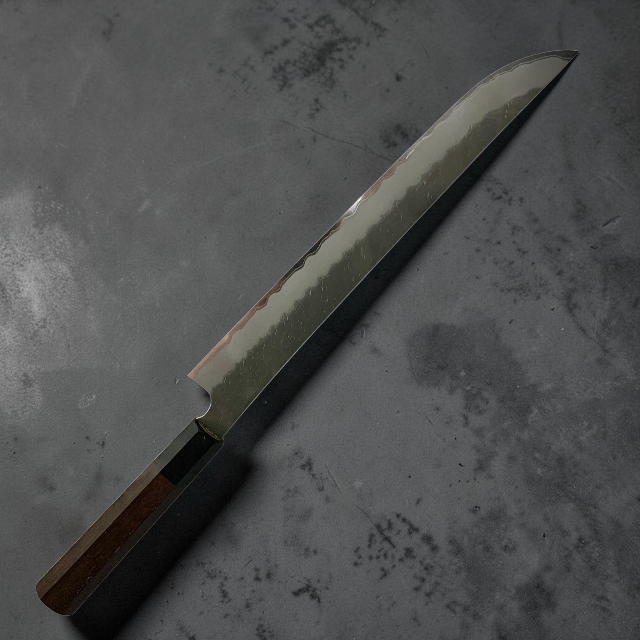 Nigara AS Tsuchime Sakimaru Sujihiki 300 mm — left-side profile highlighting graceful sakimaru tip and kasumi.