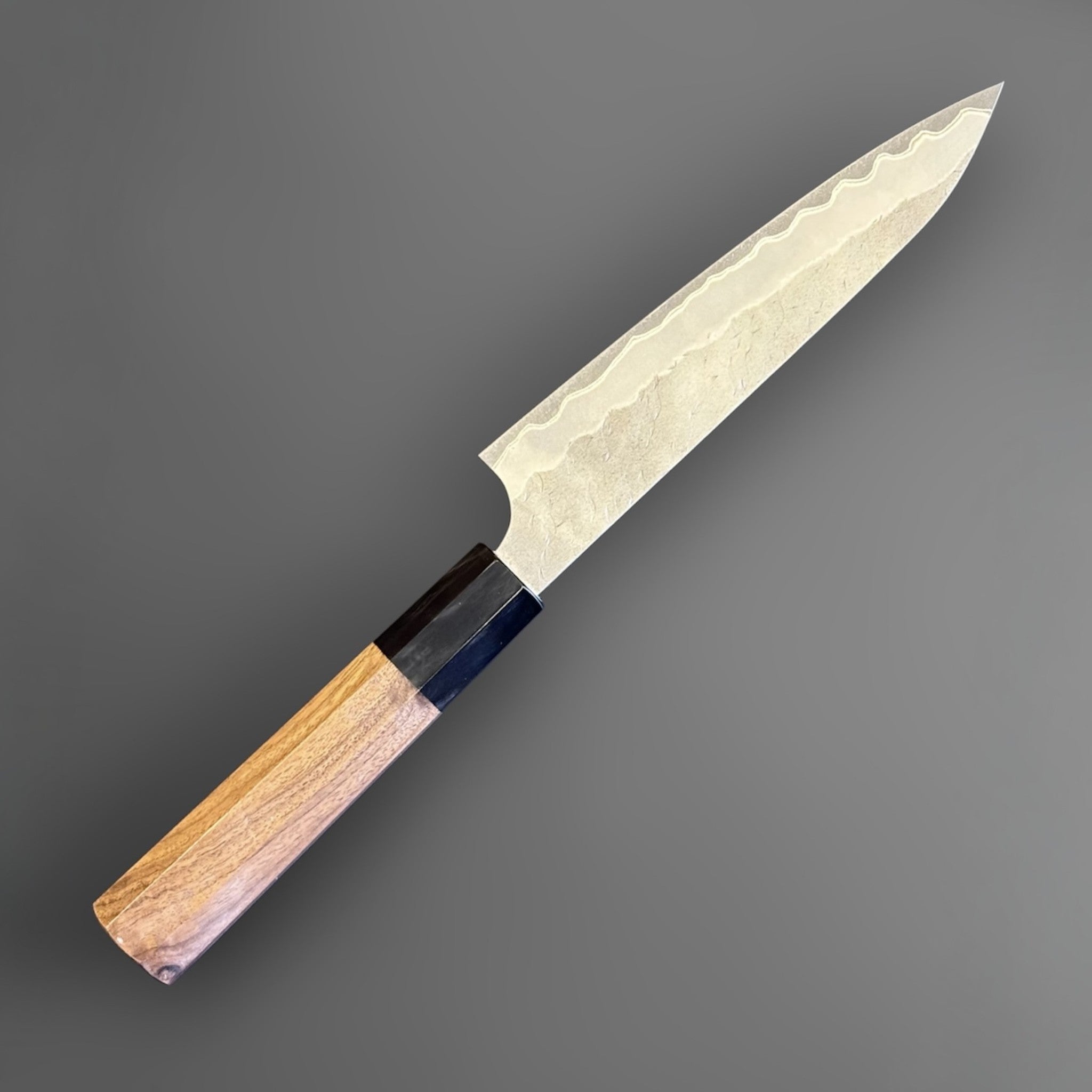 Nigara Hamono Aogami Super Tsuchime Petty 150 mm with walnut horn handle, reverse angled full knife view.