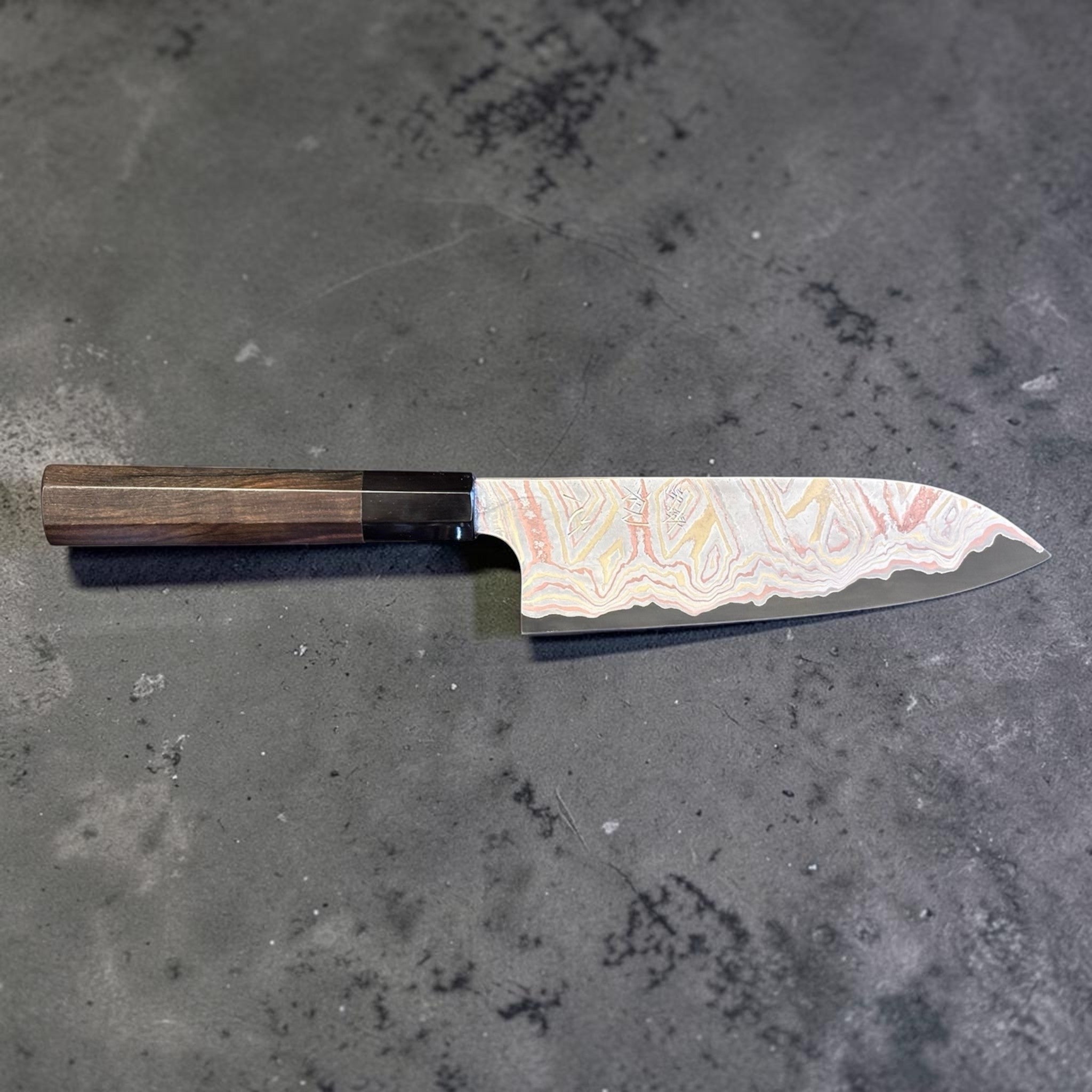 Nigara Irodori Blue #2 Rainbow Damascus Santoku 180 mm with ebony and horn handle, full profile view showing the flowing multicolor damascus pattern across the blade.